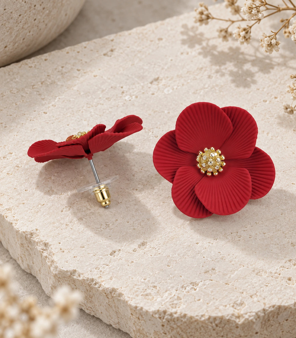 JIMIKI Red ribbed flower stud earrings, pair arranged in an editorial flat lay #color_red