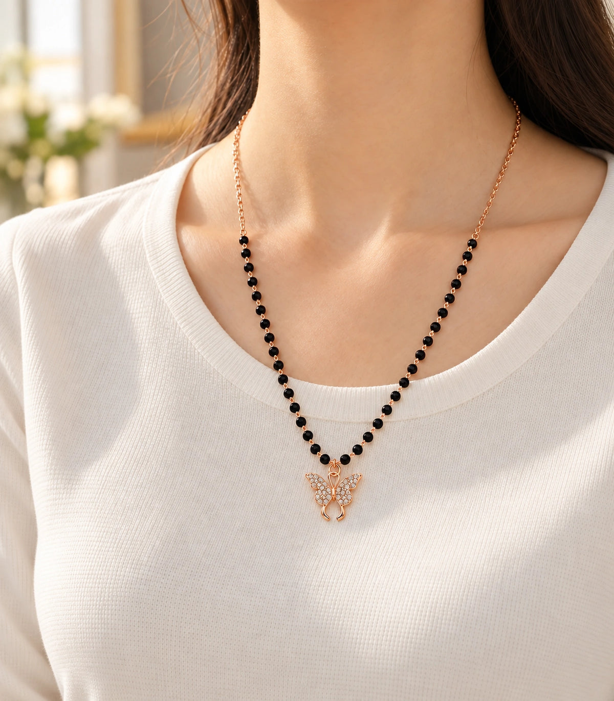 JIMIKI Rose-Gold Black-Bead Crystal Butterfly Necklace in Rose Gold / Black - editorial worn view #color_rose-gold-black