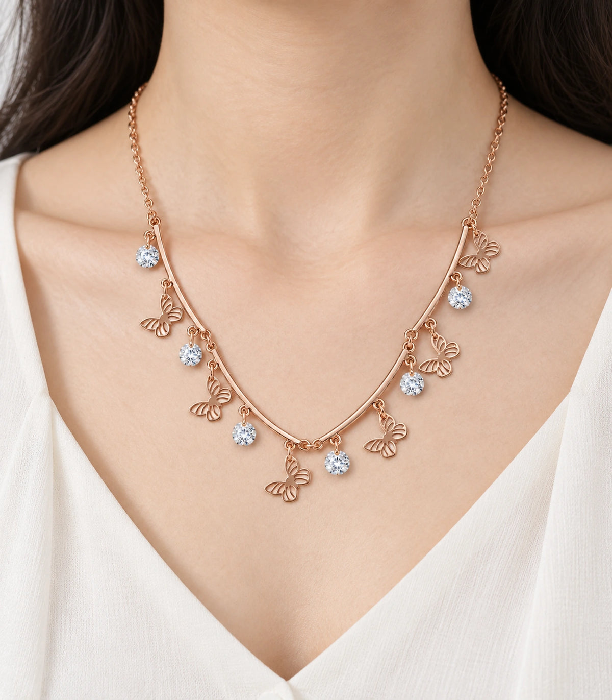 JIMIKI Rose Gold Butterfly Crystal Charm Collar Necklace in Rose Gold - close-up details #color_rose-gold