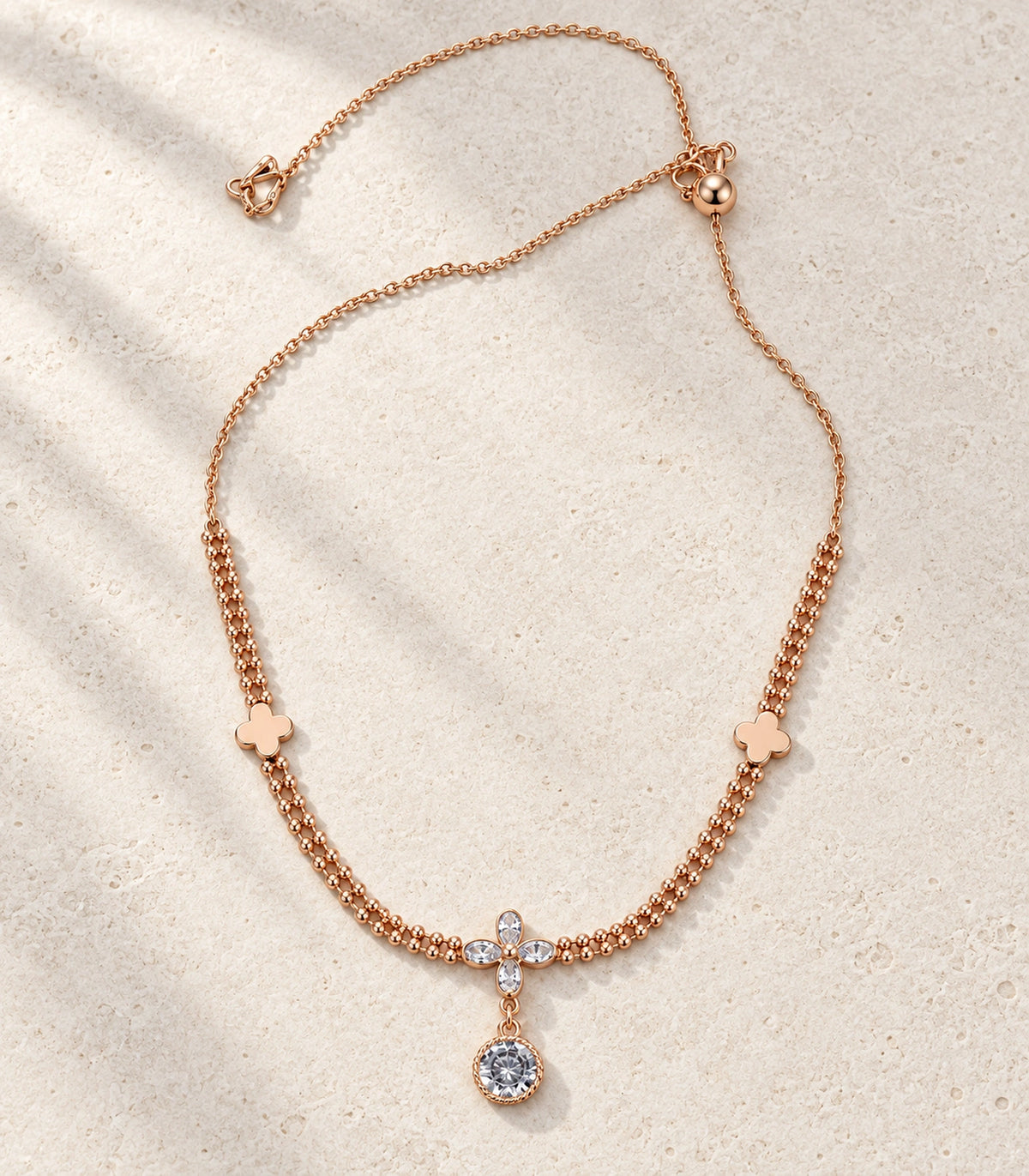 JIMIKI Clover Crystal Flower Drop Necklace in Rose Gold - editorial flatlay #color_rose-gold