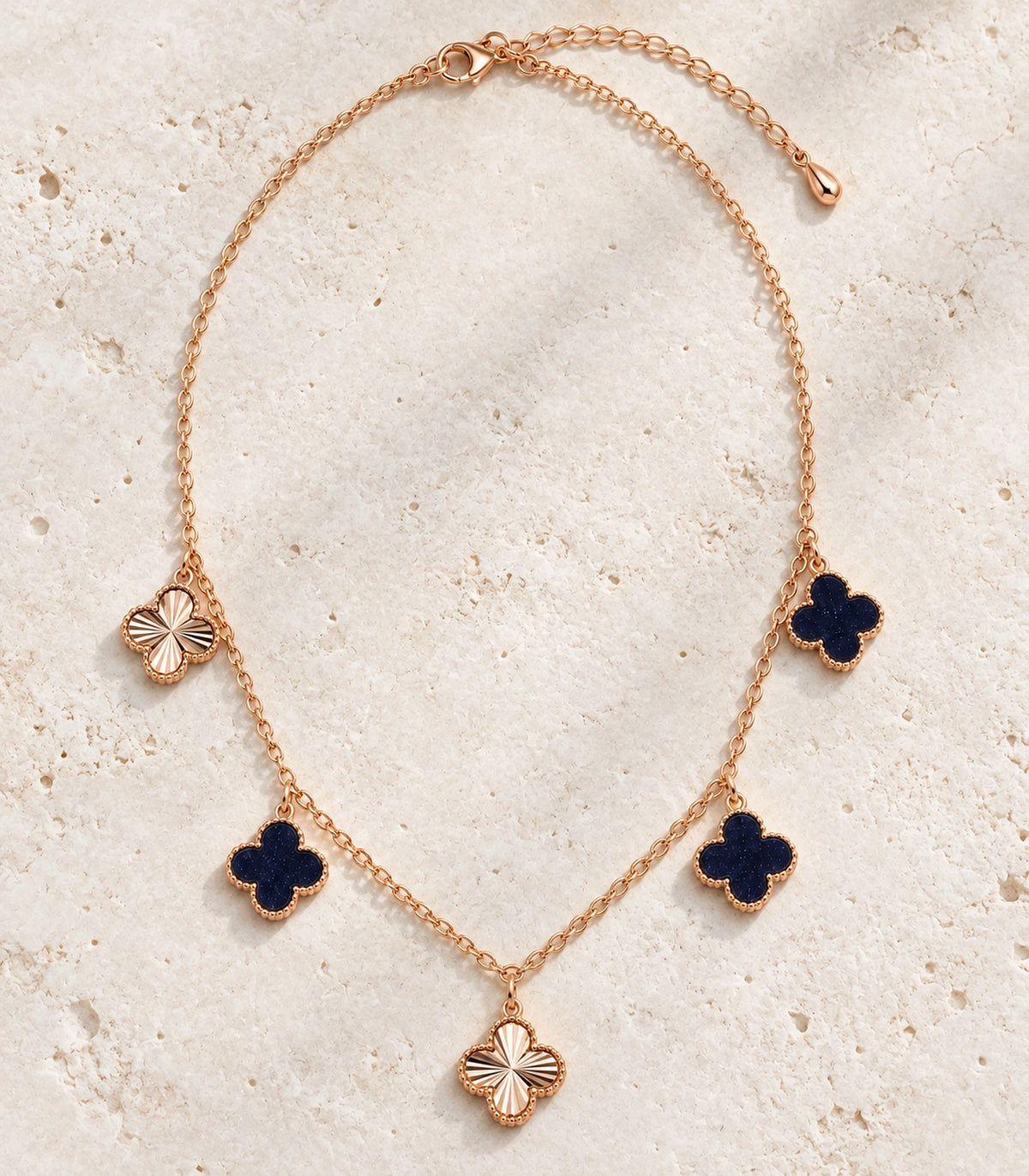 JIMIKI Rose Gold Dark Clover Charm Necklace in Rose Gold - editorial flatlay #color_rose-gold