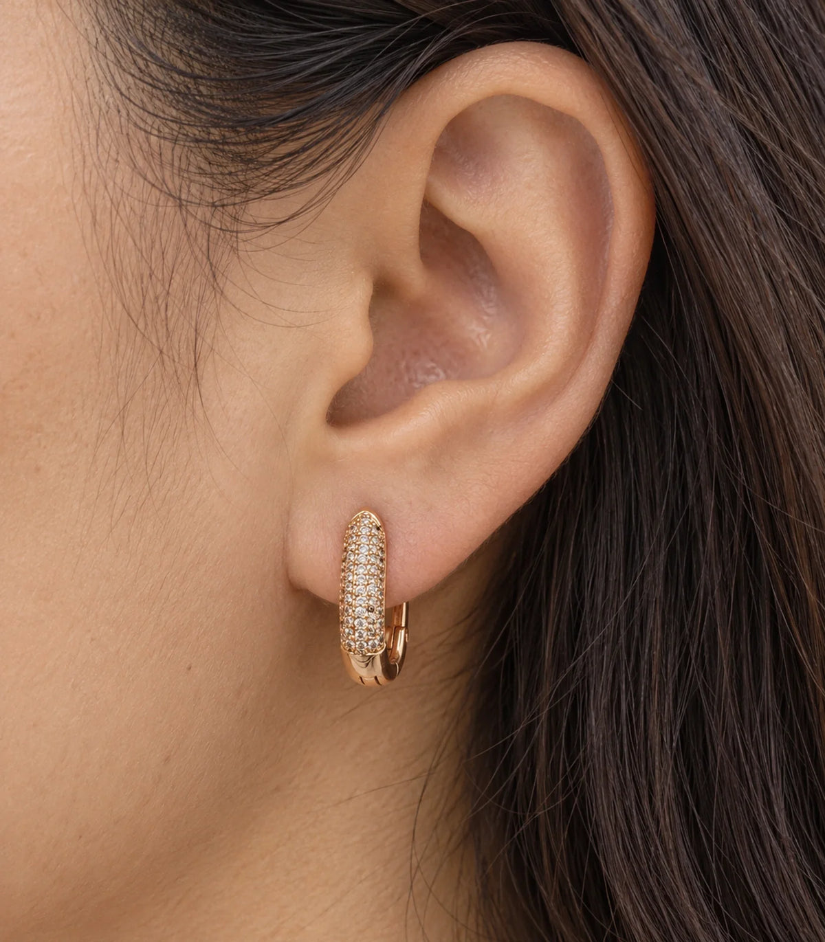 JIMIKI Pave Bar Huggie Hoop Earrings in Rose Gold Tone - worn close-up showing earring detail #color_rose-gold-tone