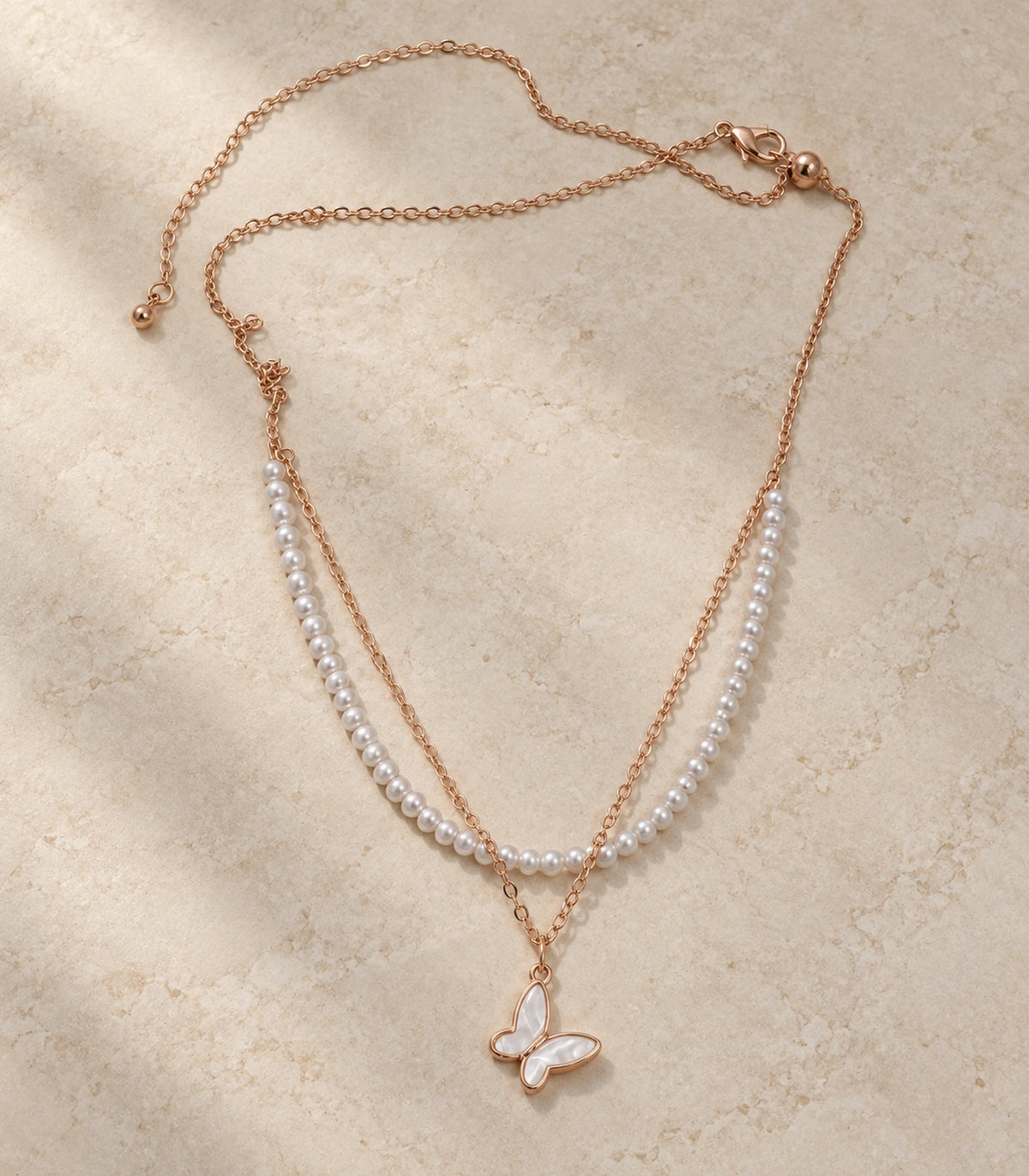 Rose Gold Pearl Butterfly Layered Necklace – editorial flatlay