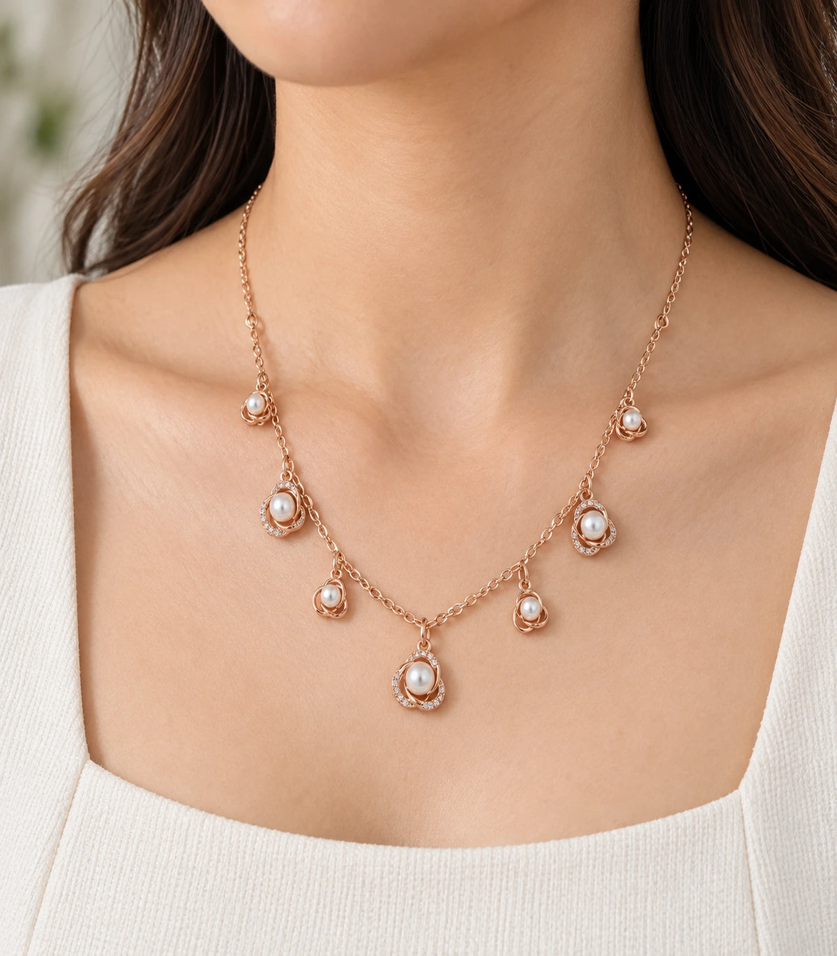 JIMIKI Rose Gold pearly rose charm necklace, worn close-up of alternating plain and sparkling floral charms #color_rose gold