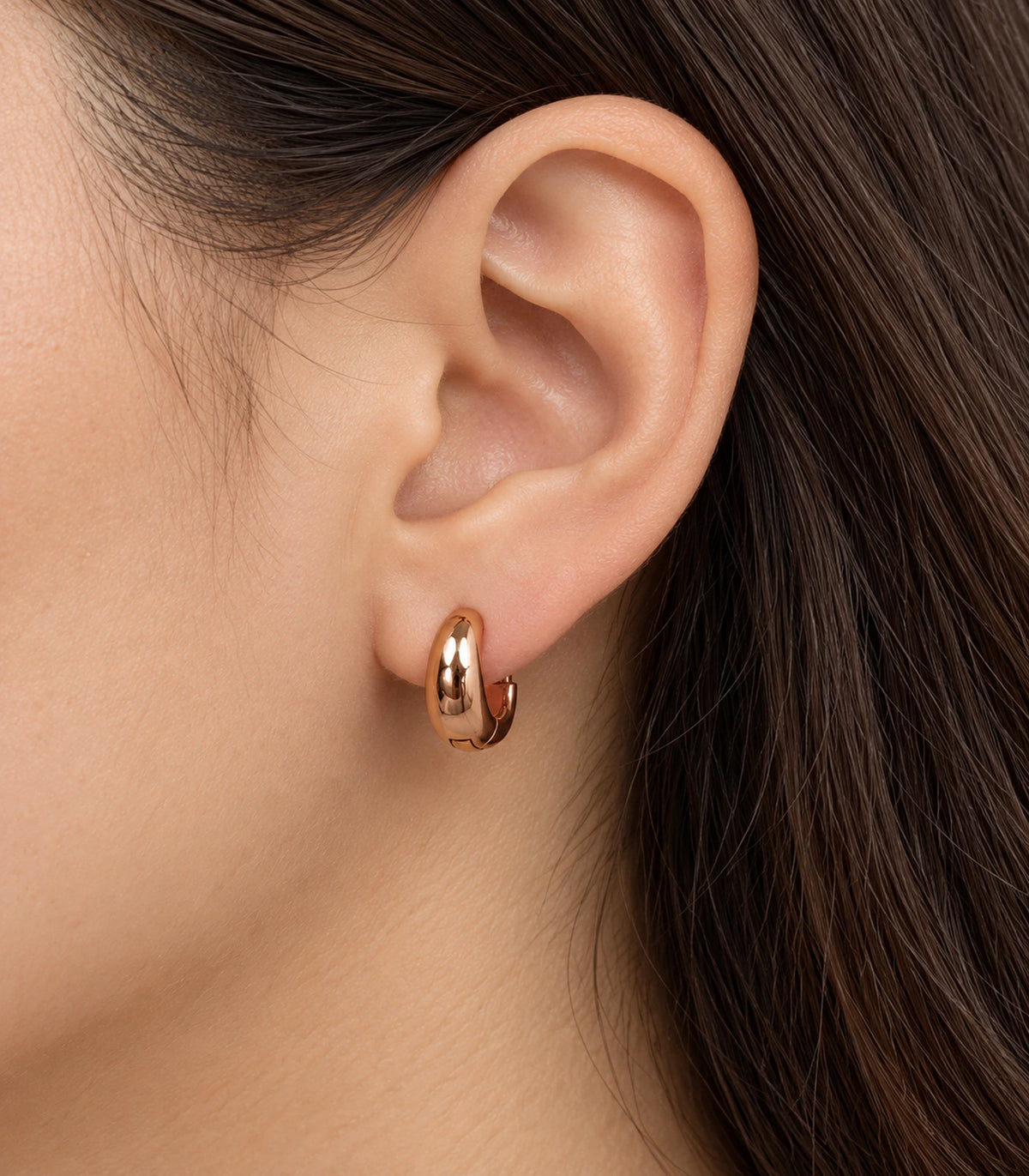 JIMIKI Smooth Tapered Huggie Earrings in Rose Gold Tone — worn styling view #color_rose-gold-tone