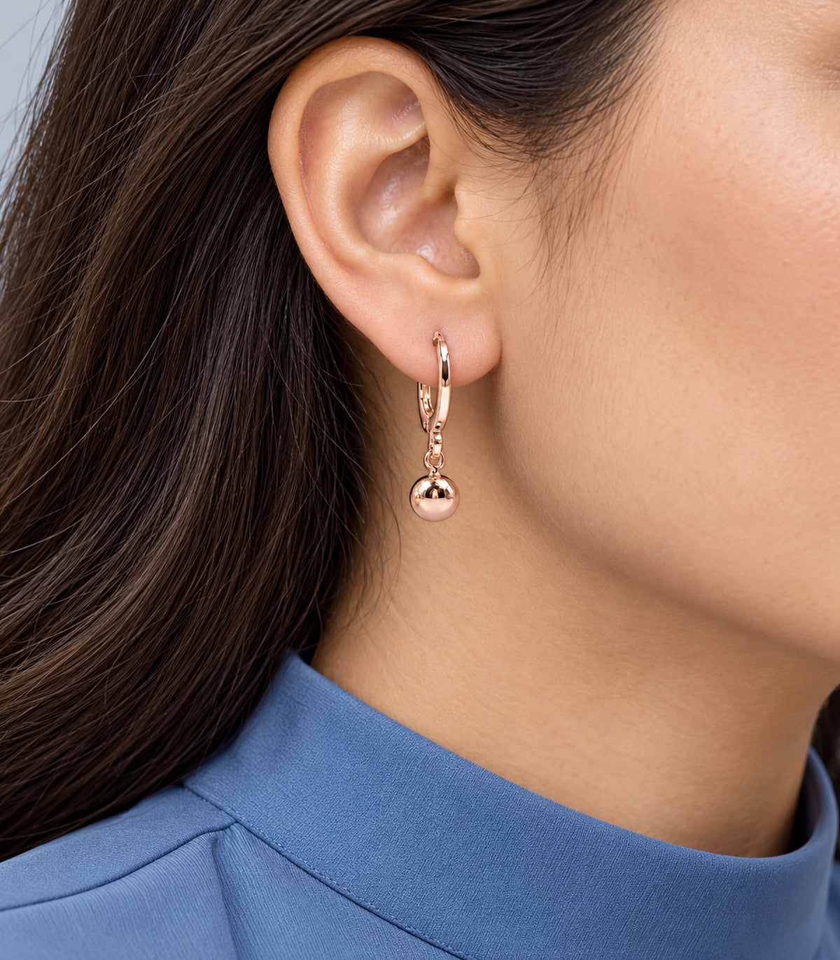 One ball charm hoop from the three-pair rose gold tone set worn on one ear #Color_Rose Gold Tone