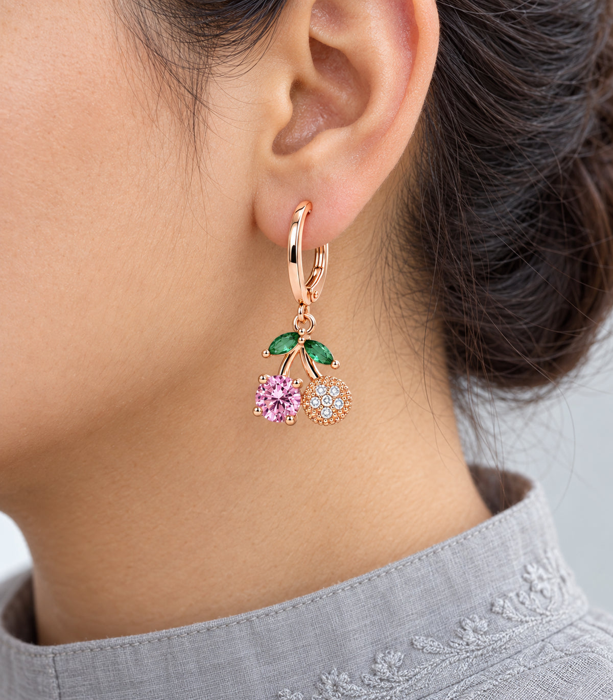 Cherry floral charm hoop with green leaves, pink stone and clear-stone disc worn close up