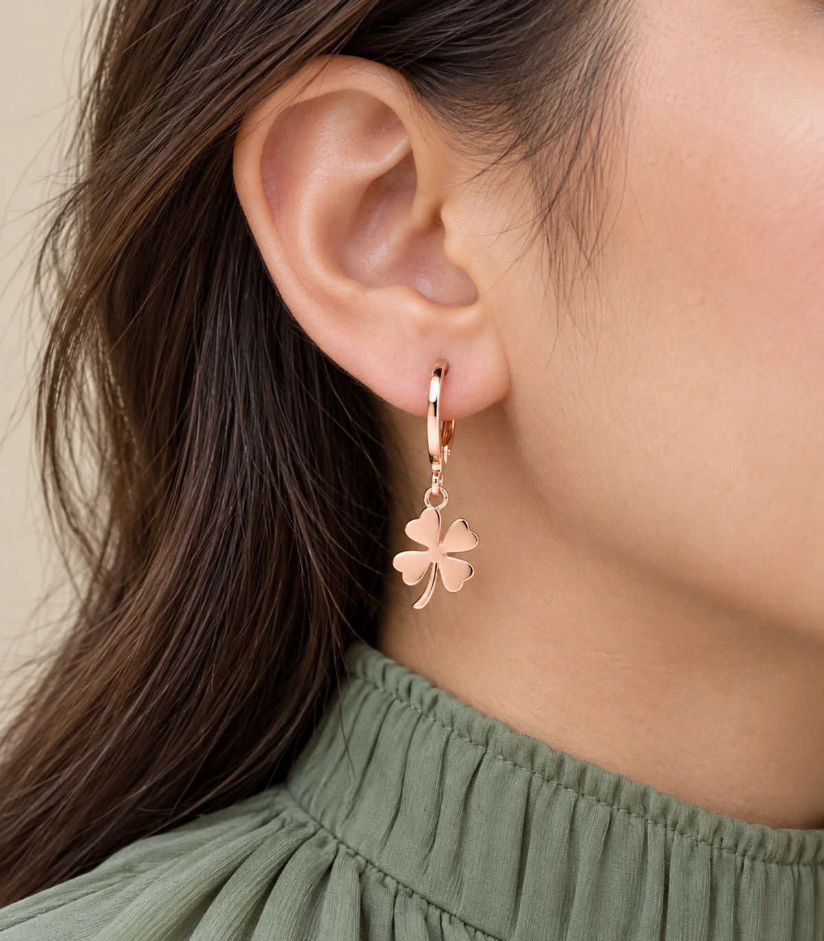 Closeup of the rose gold tone four-leaf clover hoop earring