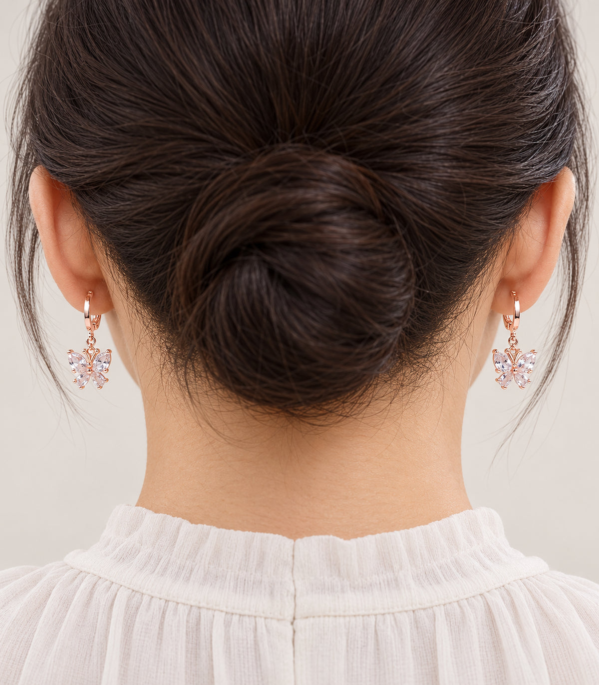 Worn view of a matching pair from the rose gold tone hoop earring set