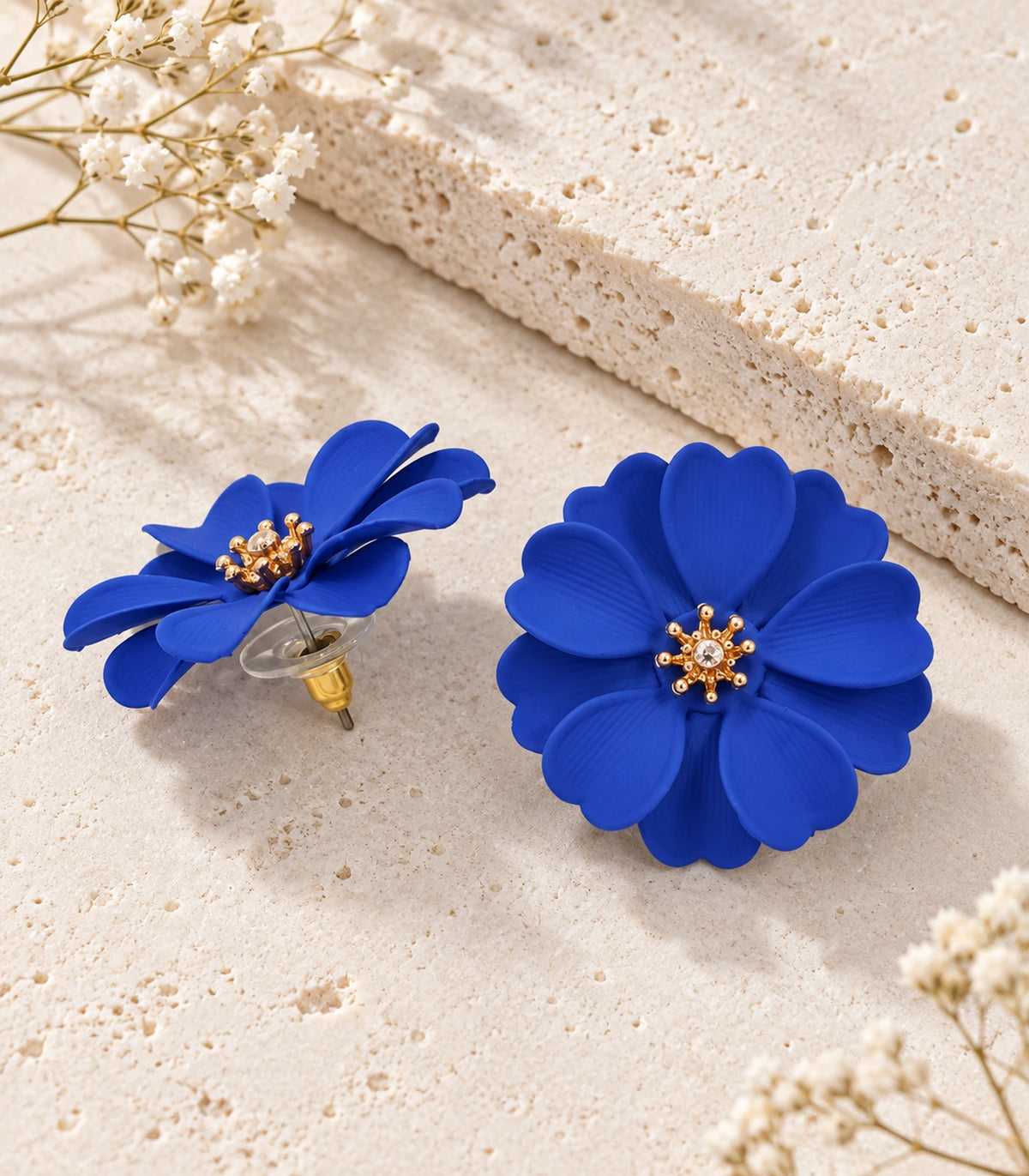 JIMIKI Royal Blue Layered Daisy Stud Earrings - pair in styled flatlay #color_royal blue