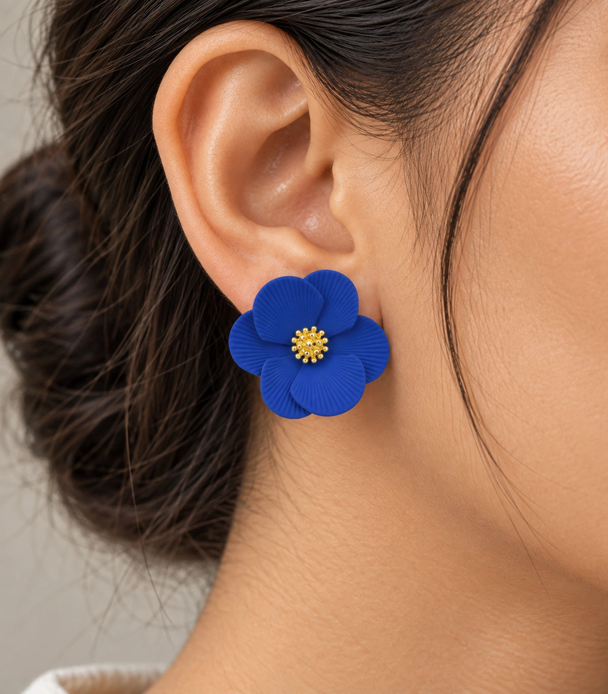 JIMIKI Royal Blue ribbed flower stud earrings, worn closeup of ribbed petals and gold-tone centre #color_royal blue