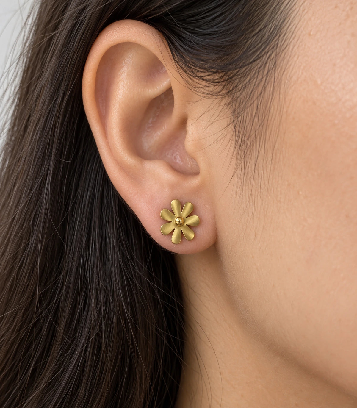 JIMIKI Satin Gold Seven-Petal Daisy Stud Earrings, worn close-up showing seven satin-finish petals and raised centre #color_satin gold