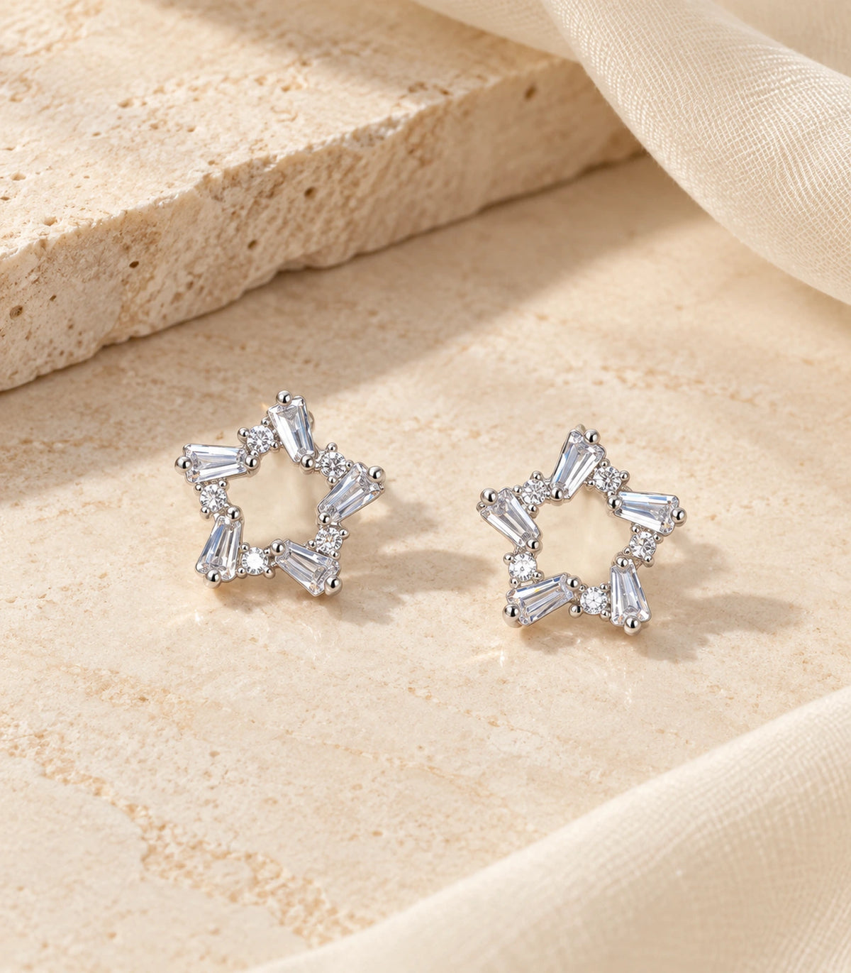 Silver Baguette Open Star Stud Earrings pair in an editorial flat lay