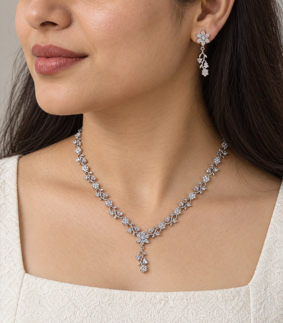 Close view of matching floral drop earring and Y-drop necklace worn naturally