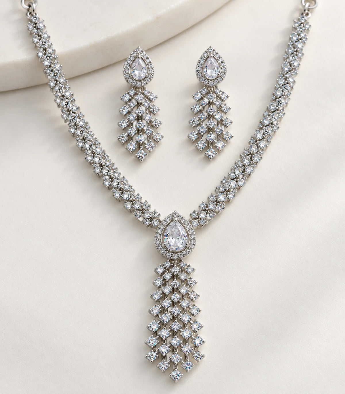 Close detail of Silver Clear Lattice Drop Crystal Necklace Set and matching earrings on fabric