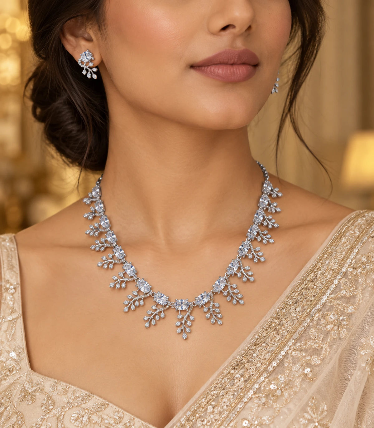 Silver-tone clear leaf-cluster necklace and matching earrings styled with a gold-toned saree