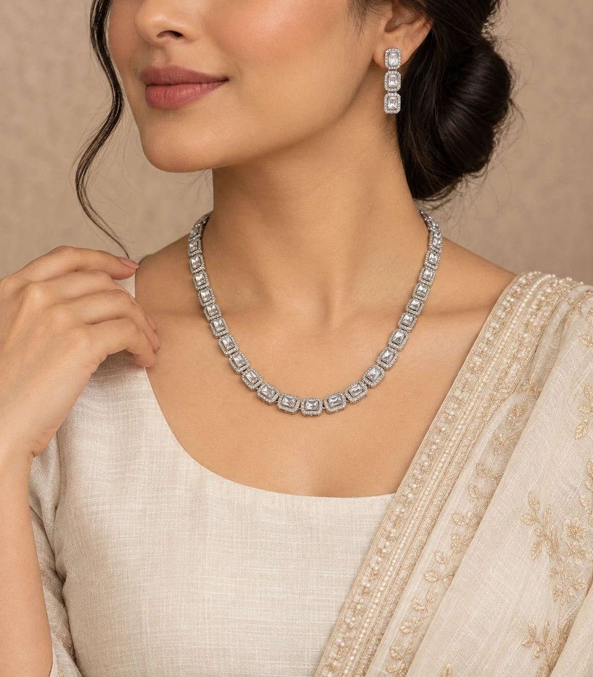 Silver-tone clear halo necklace and matching drop earring in a turned worn pose