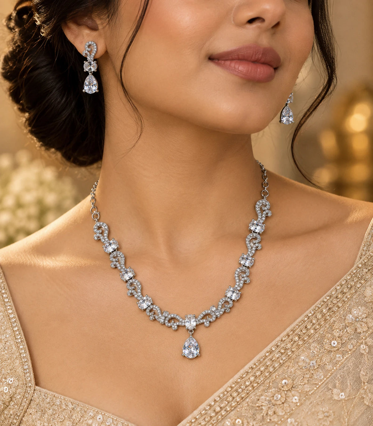 Silver clear paisley necklace set worn with a gold and ivory outfit in warm light