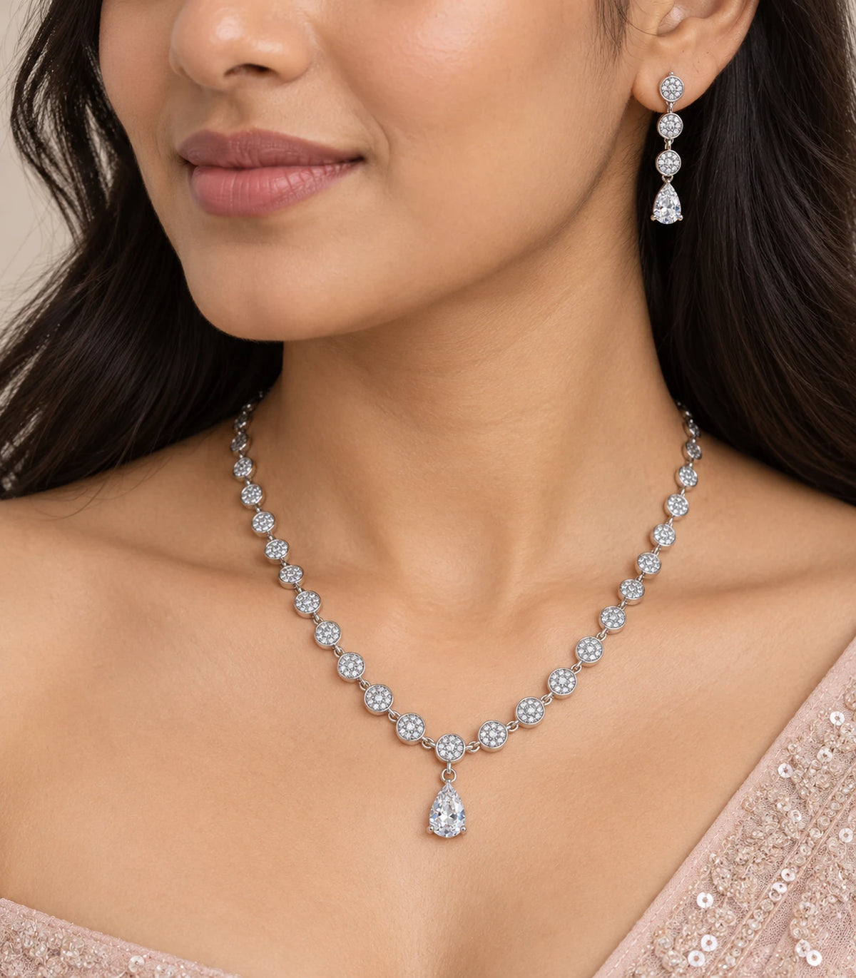 Close view of silver clear round crystal drop necklace and matching earring worn