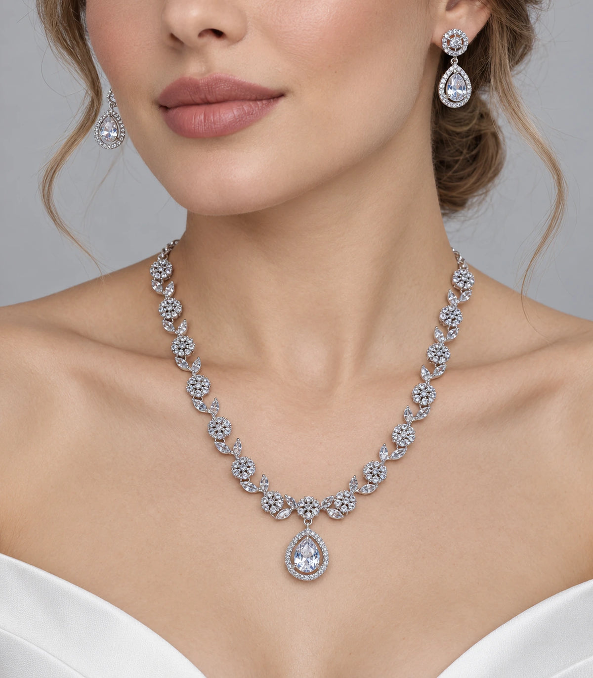 Silver clear crystal necklace and matching earrings worn with a white outfit