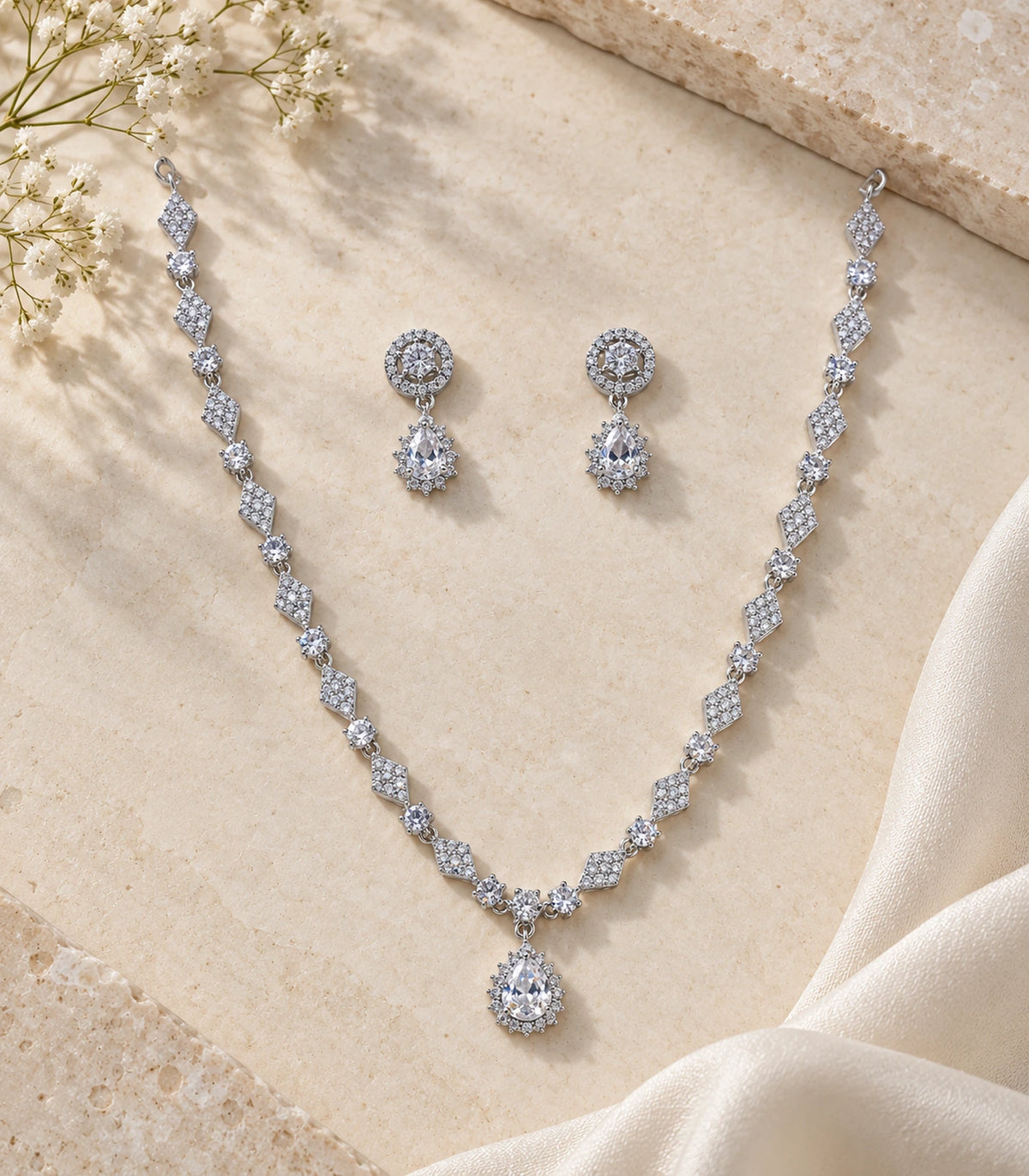 Complete silver-tone clear necklace set and matching earrings on a styled flatlay