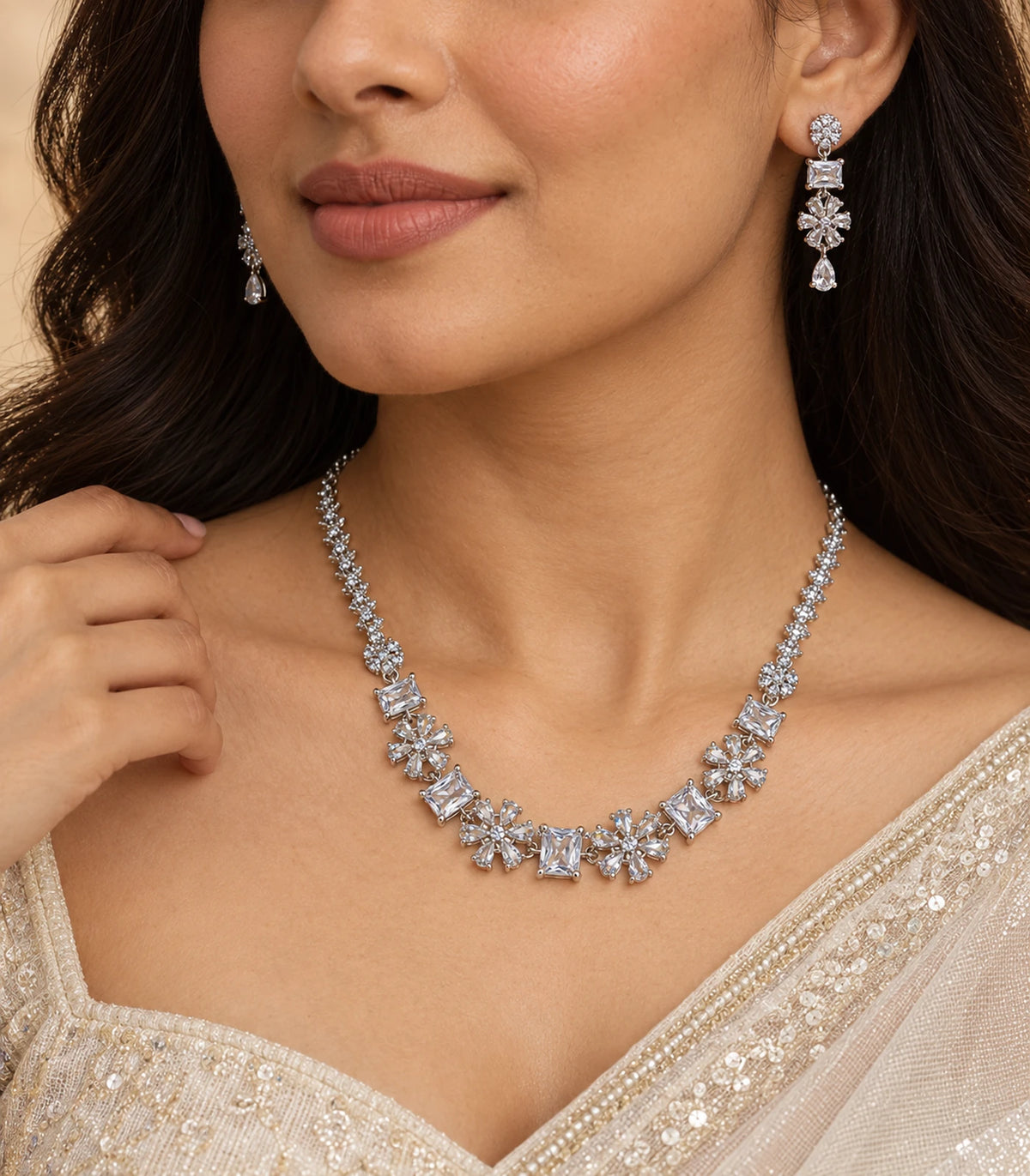 Silver-tone clear crystal necklace set worn in a turned pose with an ivory saree