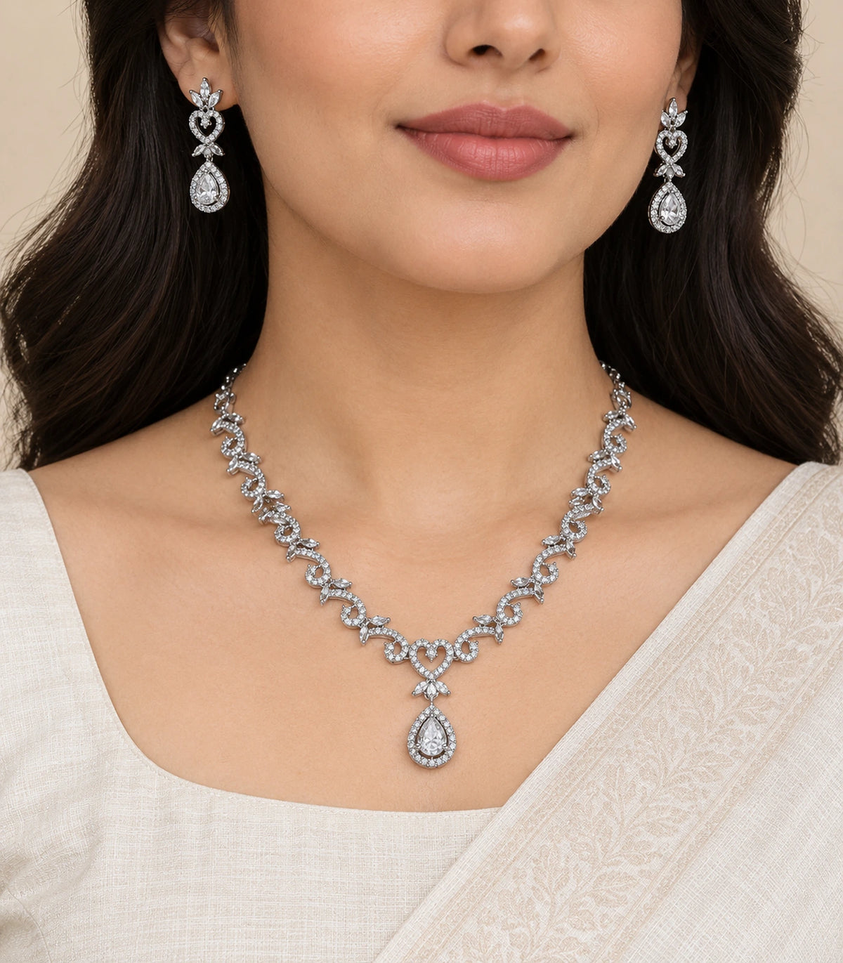 Silver-tone clear necklace and matching heart teardrop earrings worn together; eyes outside frame