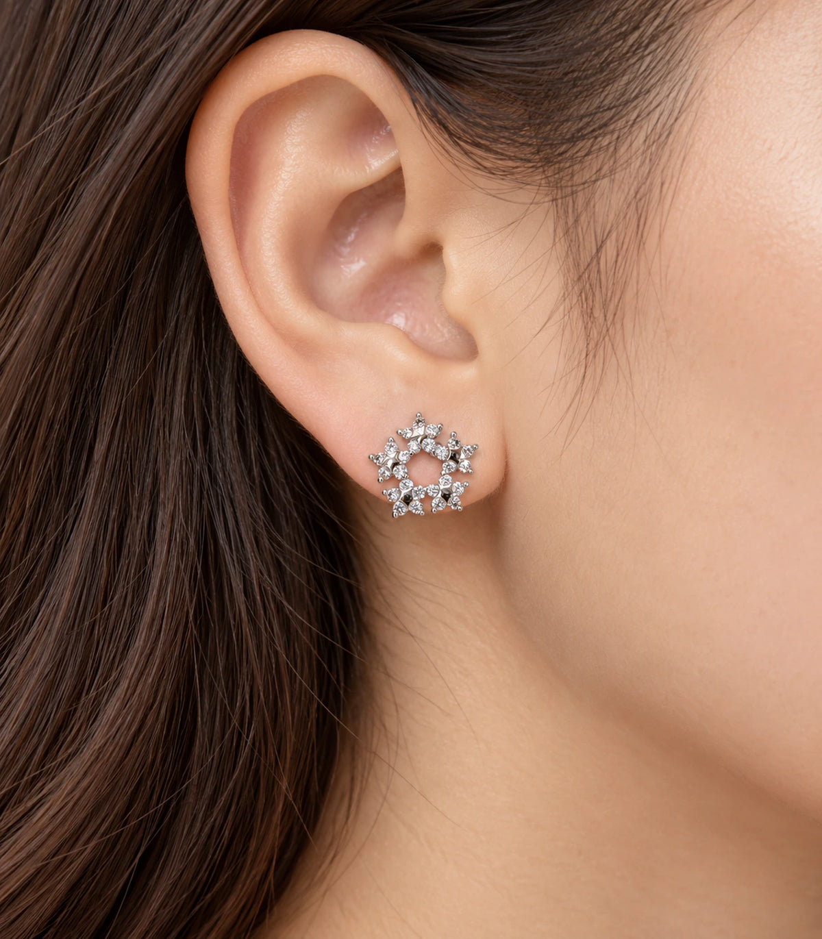 Silver-tone butterfly wreath stud earring worn at the ear in a close side view
