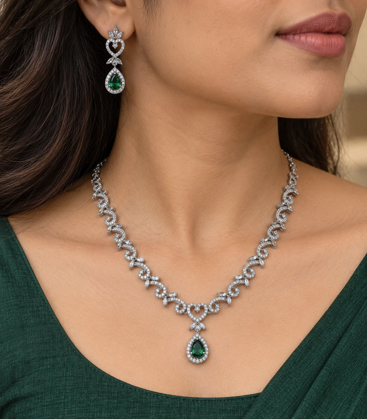 Close view of the worn green teardrop necklace and matching heart-detail earring