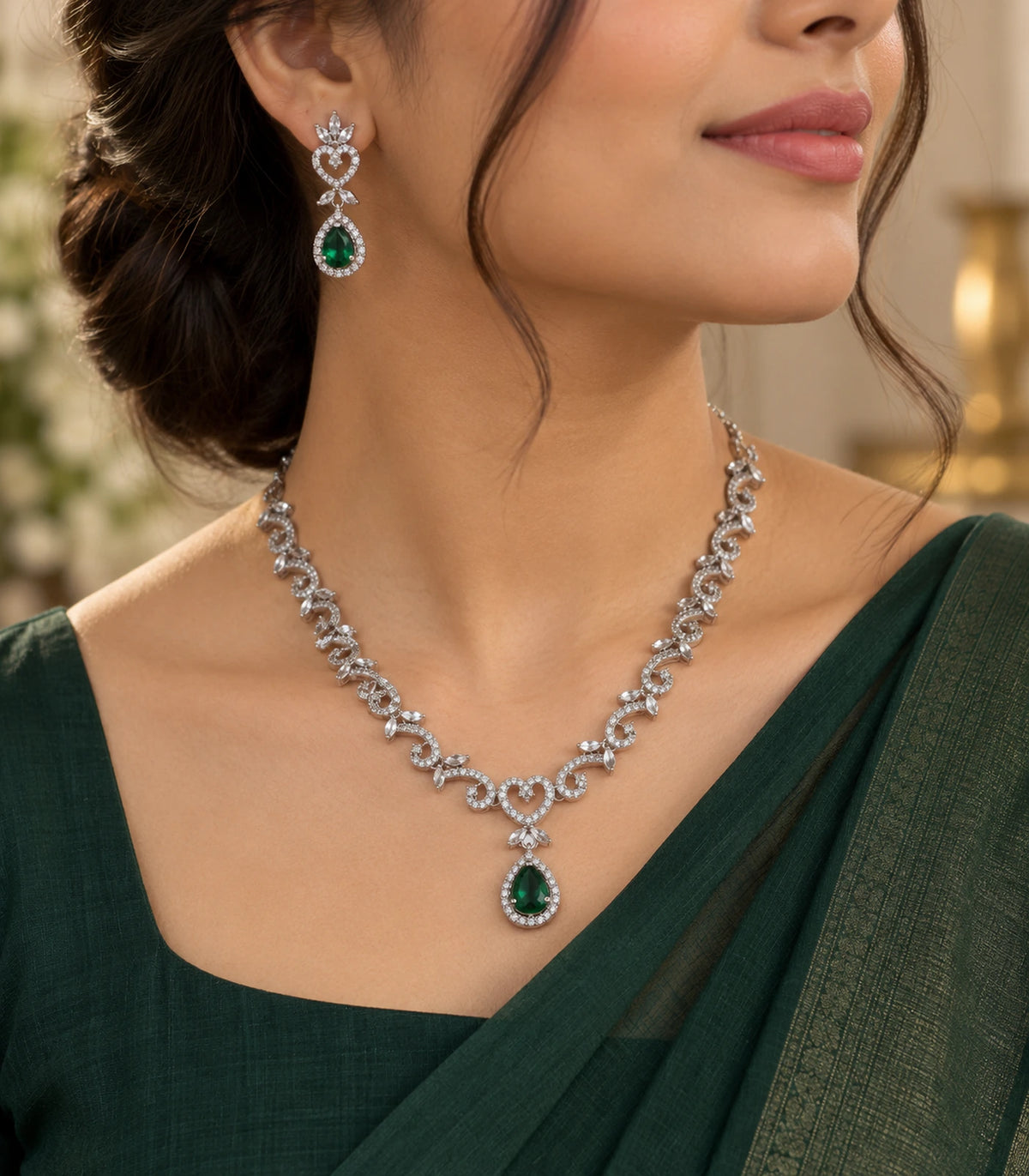 Three-quarter worn view of the silver-tone necklace and matching green teardrop earring