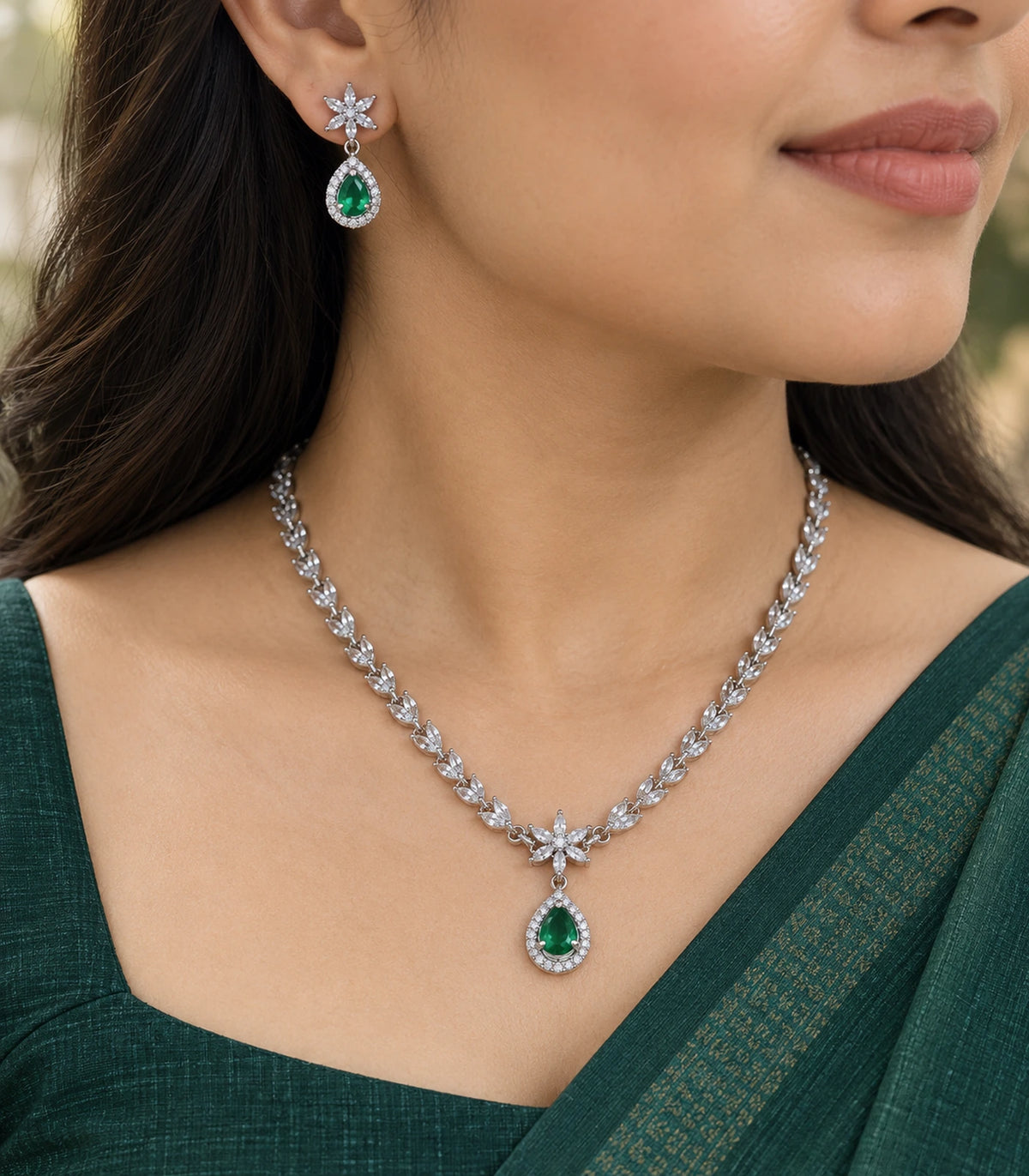 Close view of the emerald-green teardrop necklace pendant and matching floral drop earring