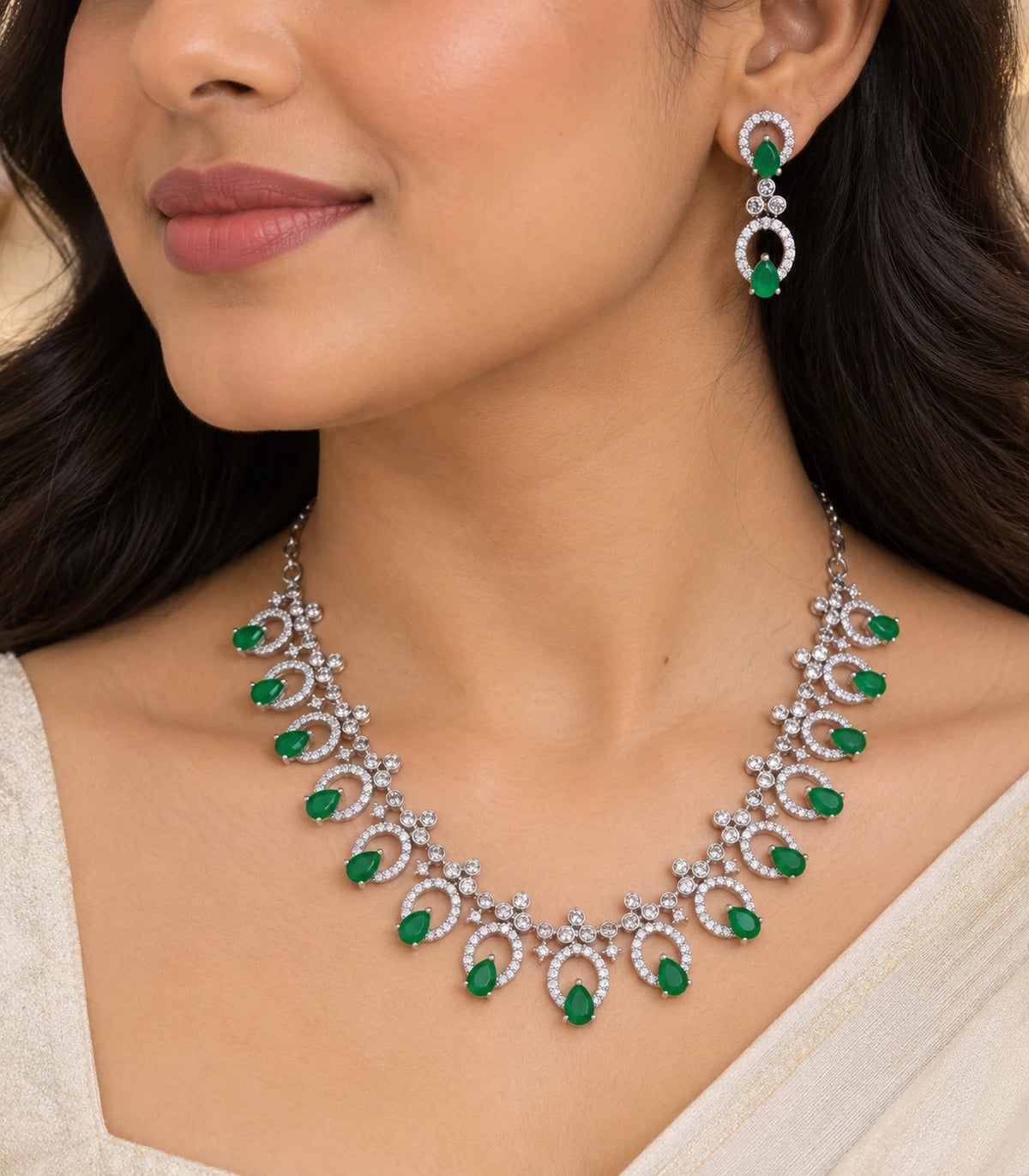 Close view of the silver-tone emerald-green necklace and matching drop earring