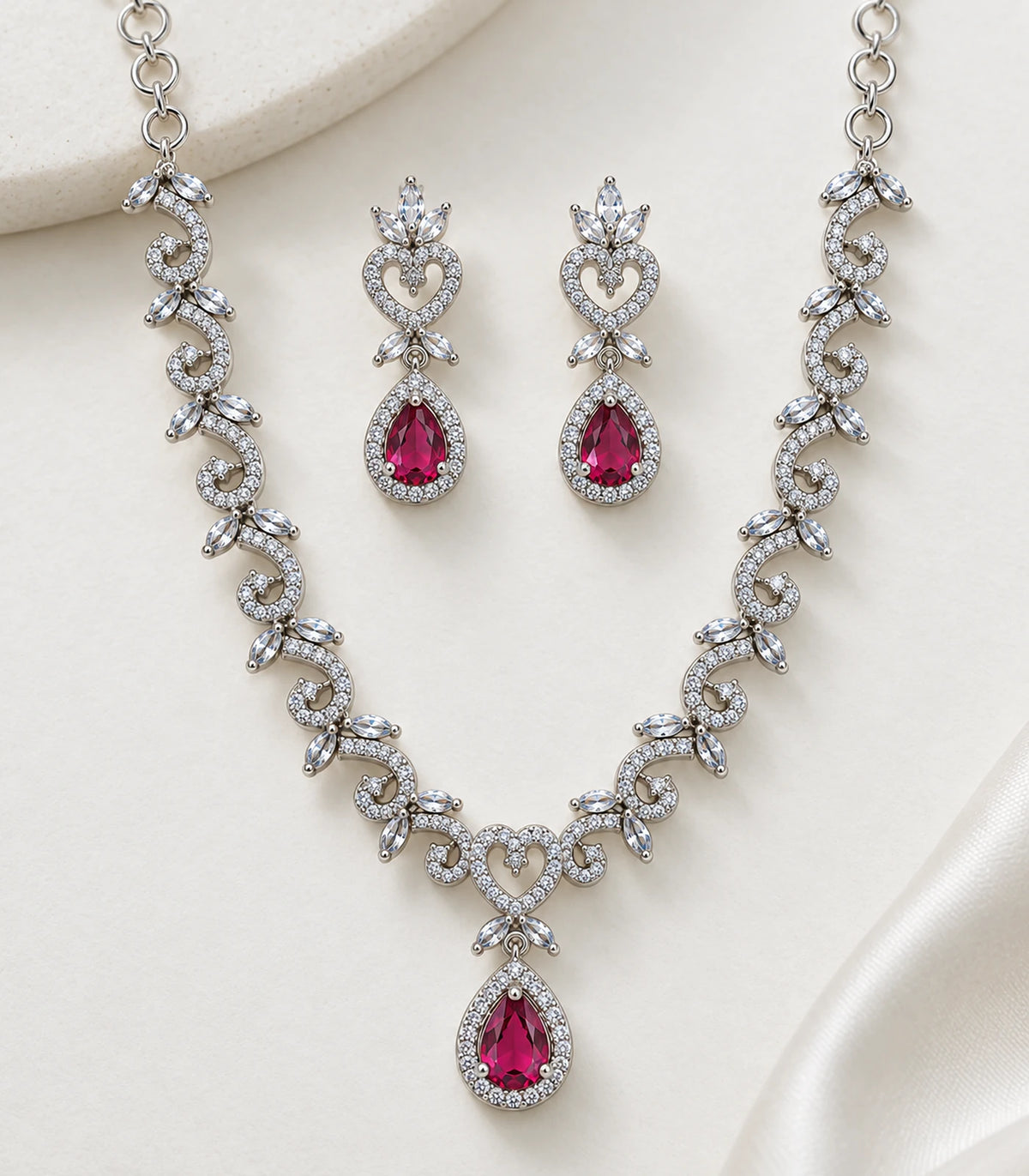 Detailed view of the silver magenta heart teardrop necklace and matching earrings