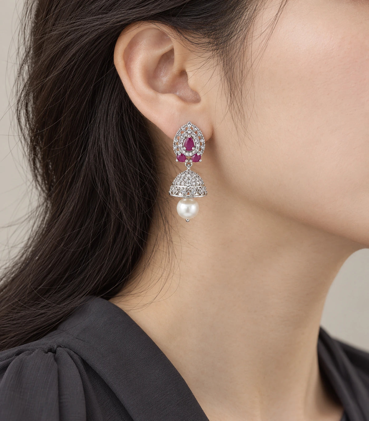 Silver-tone magenta lattice jhumka earring worn at the ear with dark clothing
