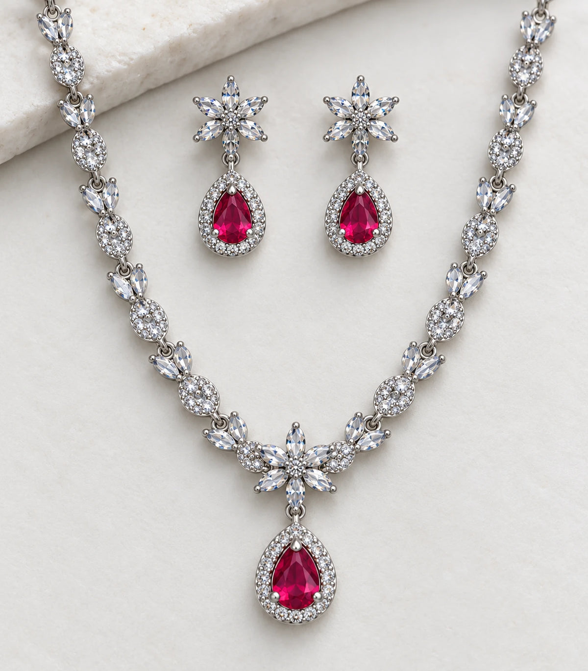 Detail of the floral motifs and magenta teardrops in the necklace set