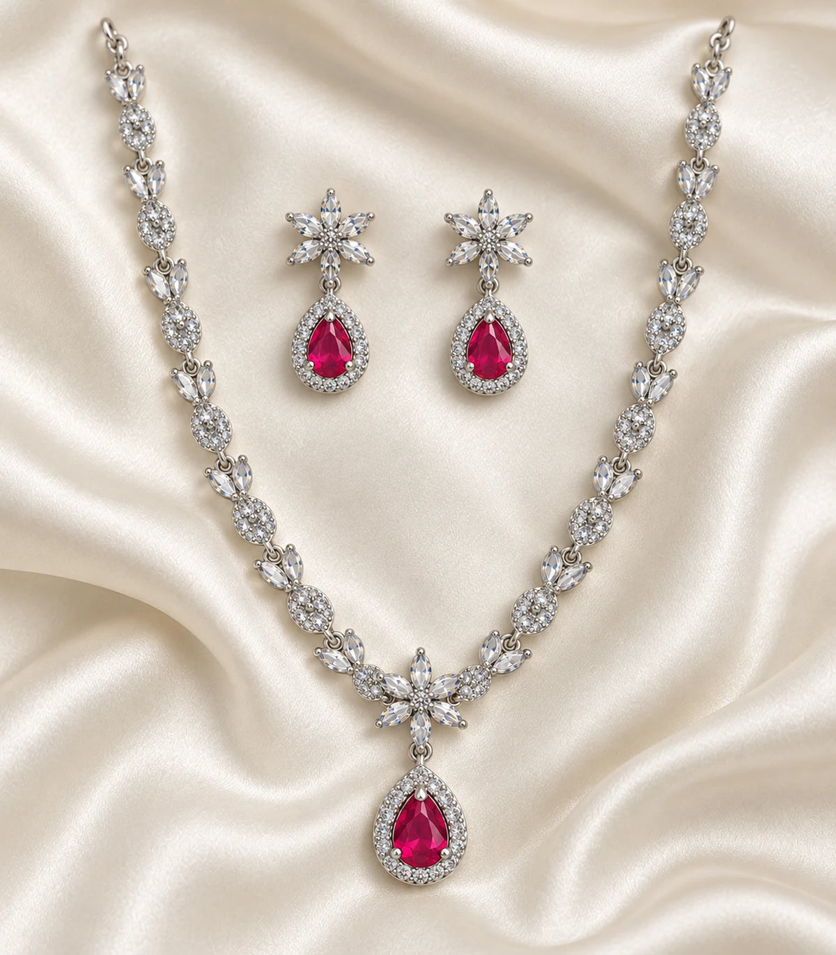 Silver Magenta Teardrop Floral Crystal Necklace Set and matching earrings arranged on fabric
