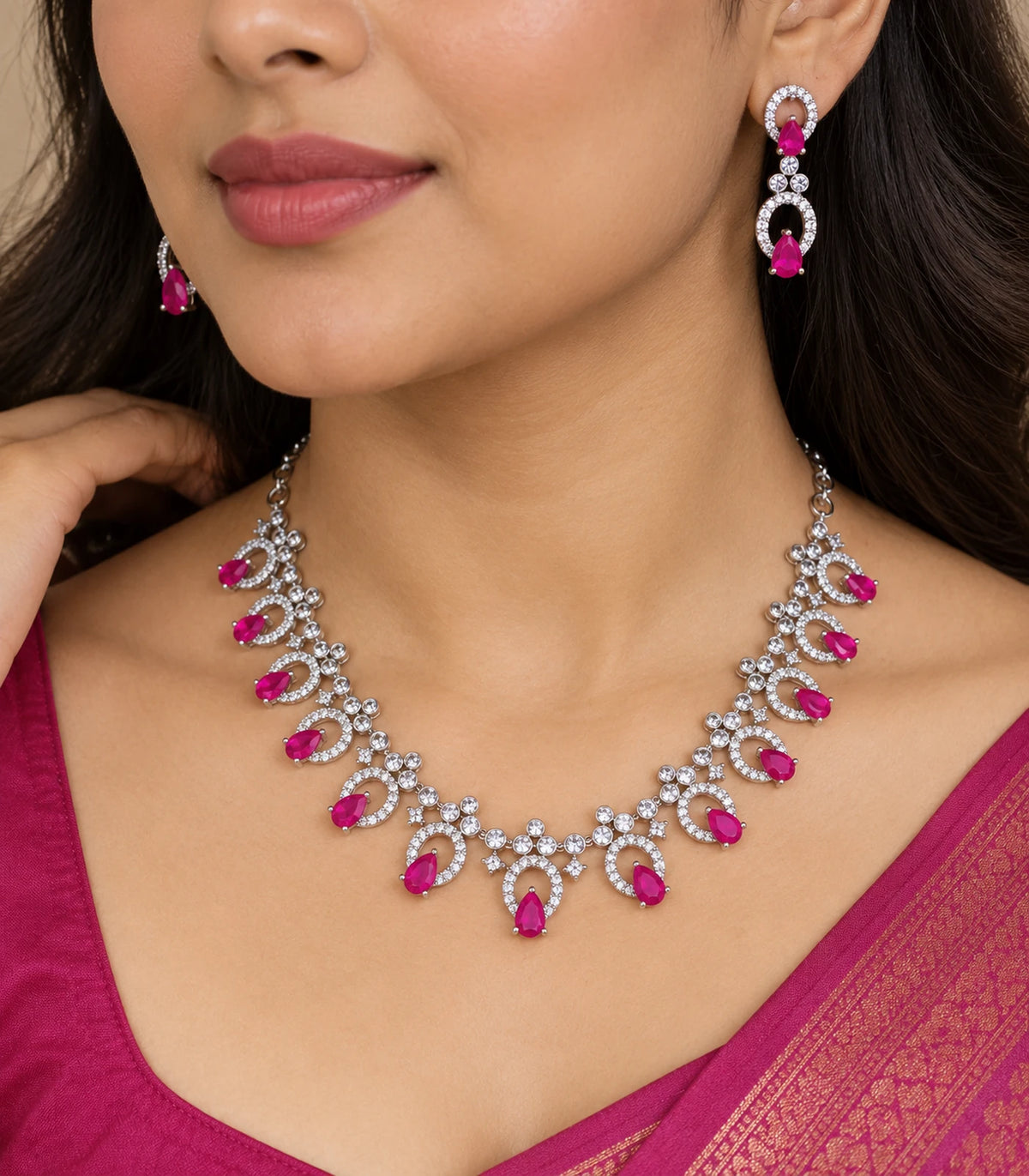 Close view of the silver-tone magenta teardrop necklace and matching drop earring