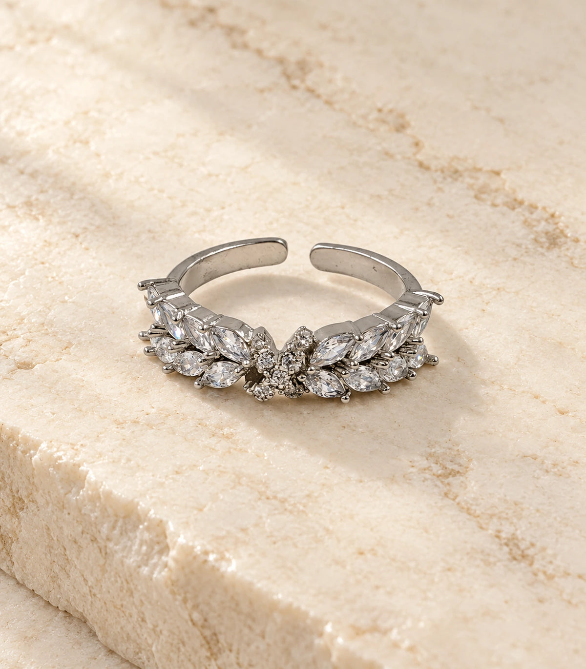Complete silver marquise leaf wing open ring on a stone flatlay surface