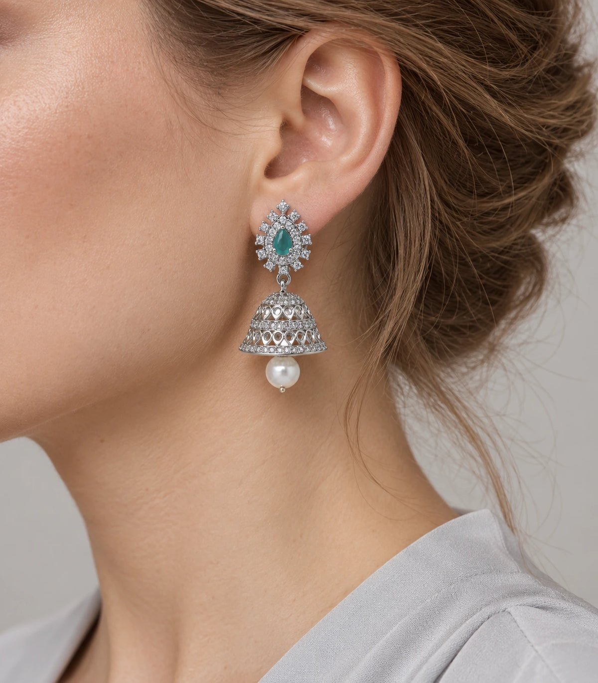 Mint teardrop silver-tone jhumka earring with a pearl-look drop worn beside the ear