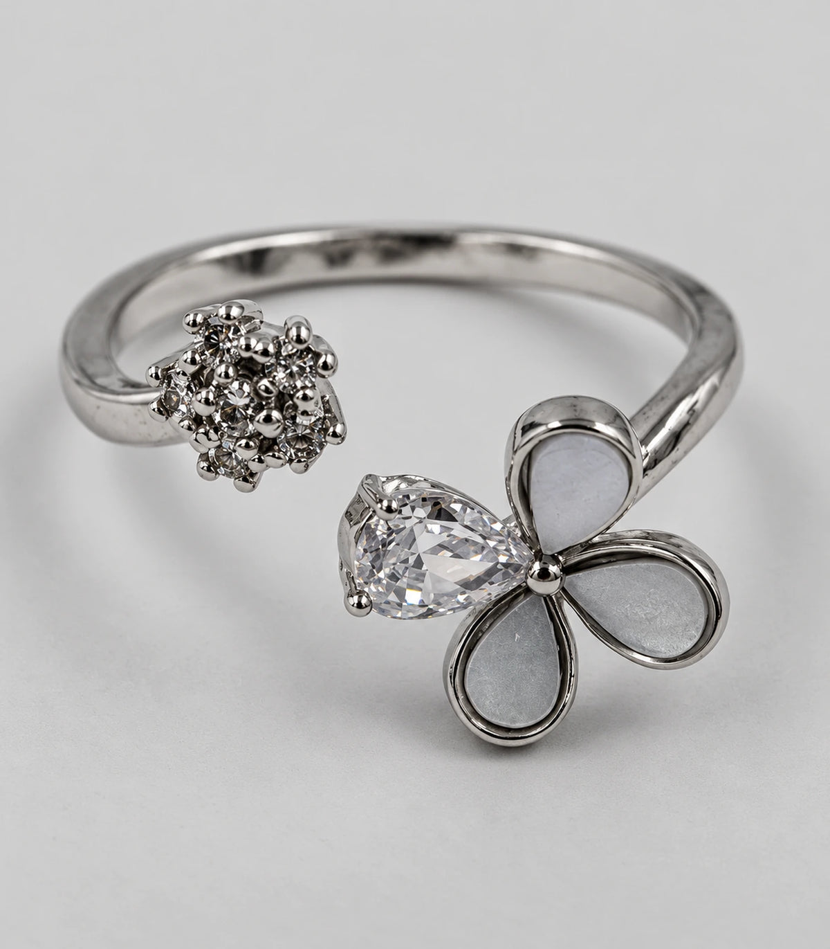 Detailed view of the silver-tone open ring, pale teardrop petals and clear crystal accents