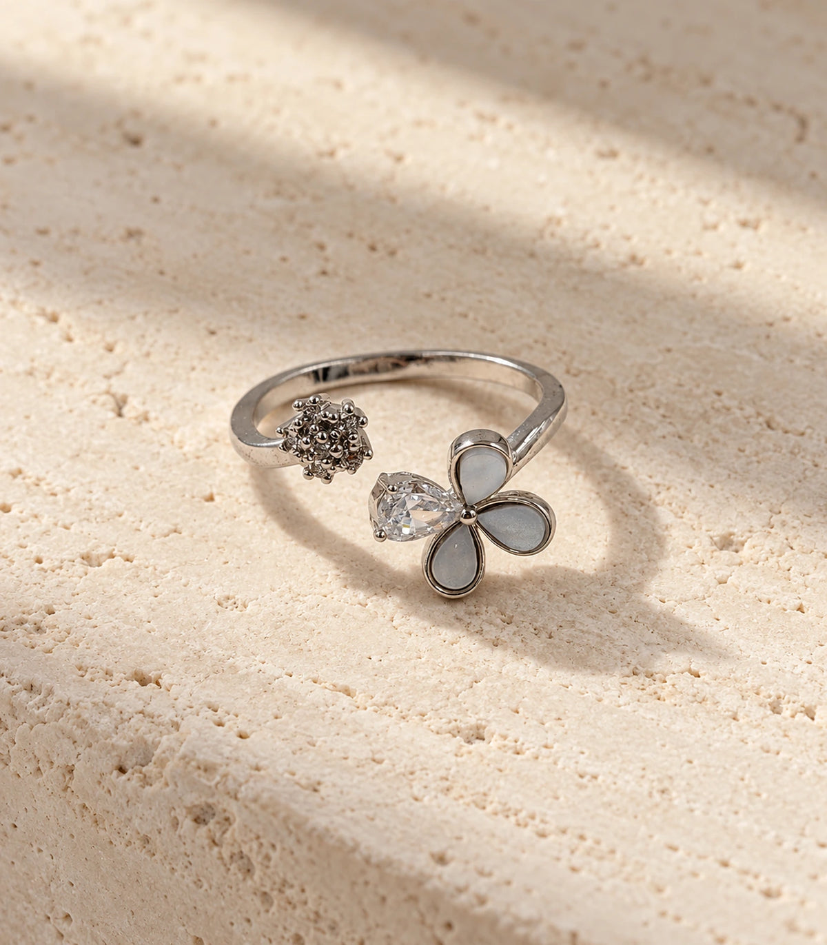 Complete silver-tone flower and crystal open ring on neutral stone