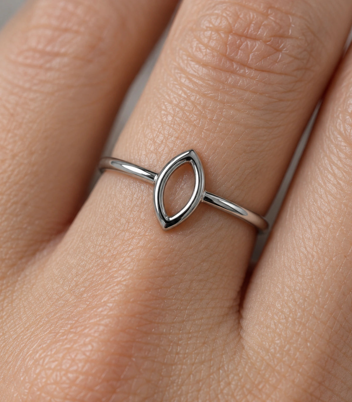 Close view of the silver-tone hollow marquise ring worn on a finger