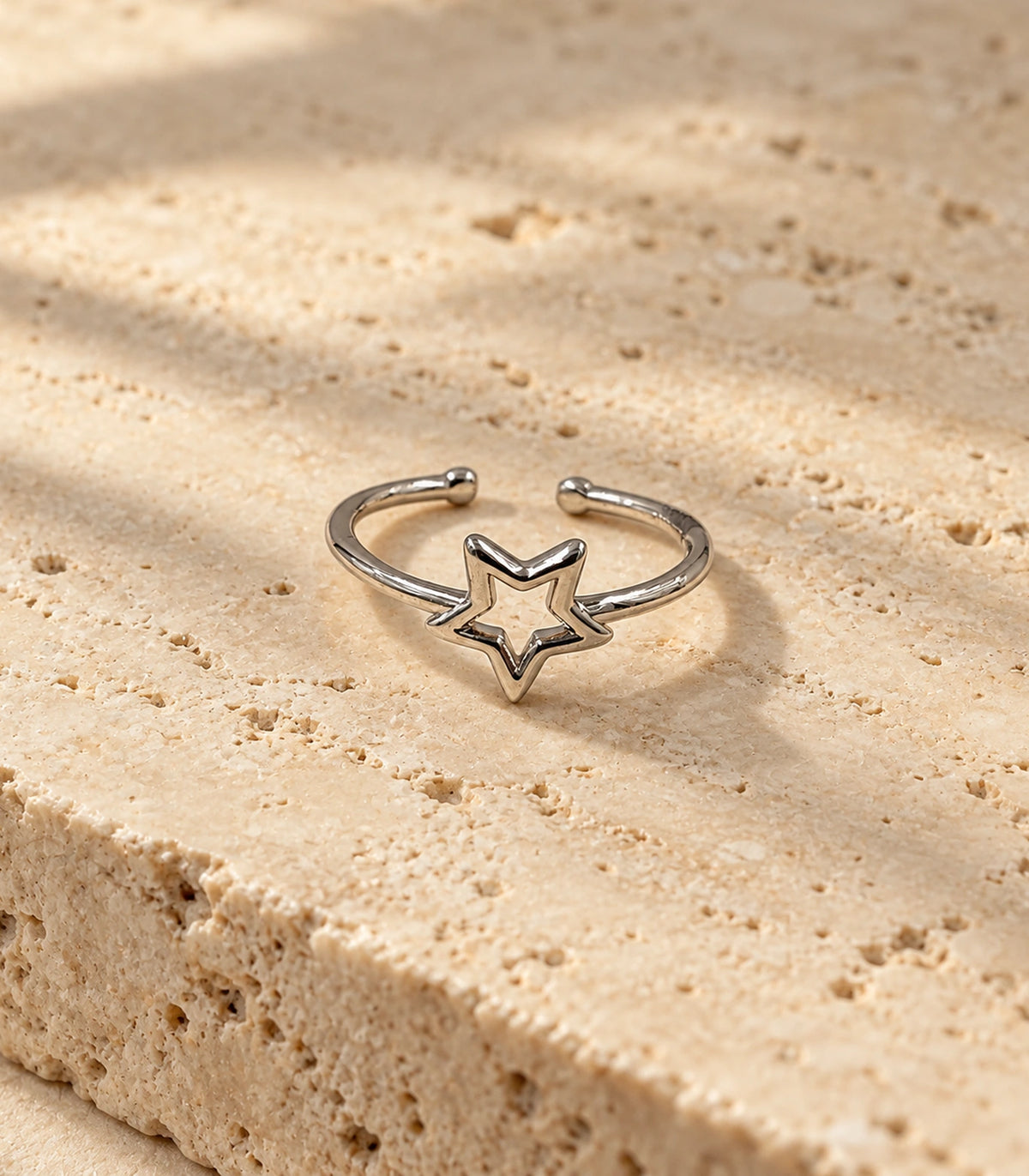 Silver Open Star Minimal Ring on a textured neutral surface