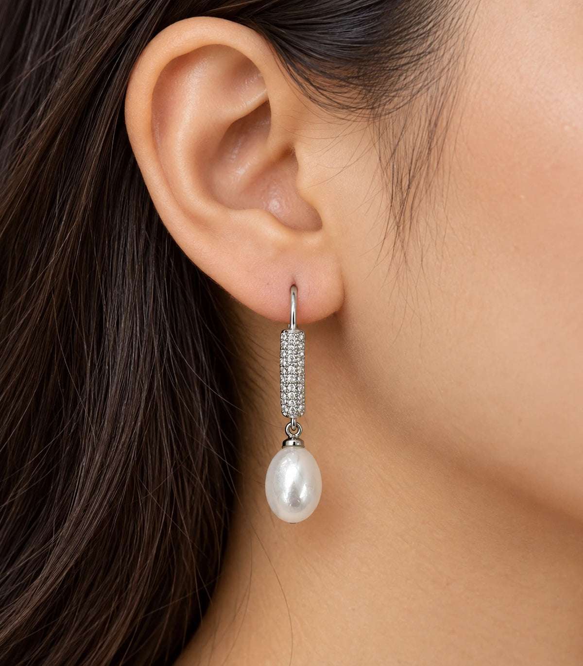 Silver-tone pavé bar earring with a white teardrop pearl-style drop worn at the ear