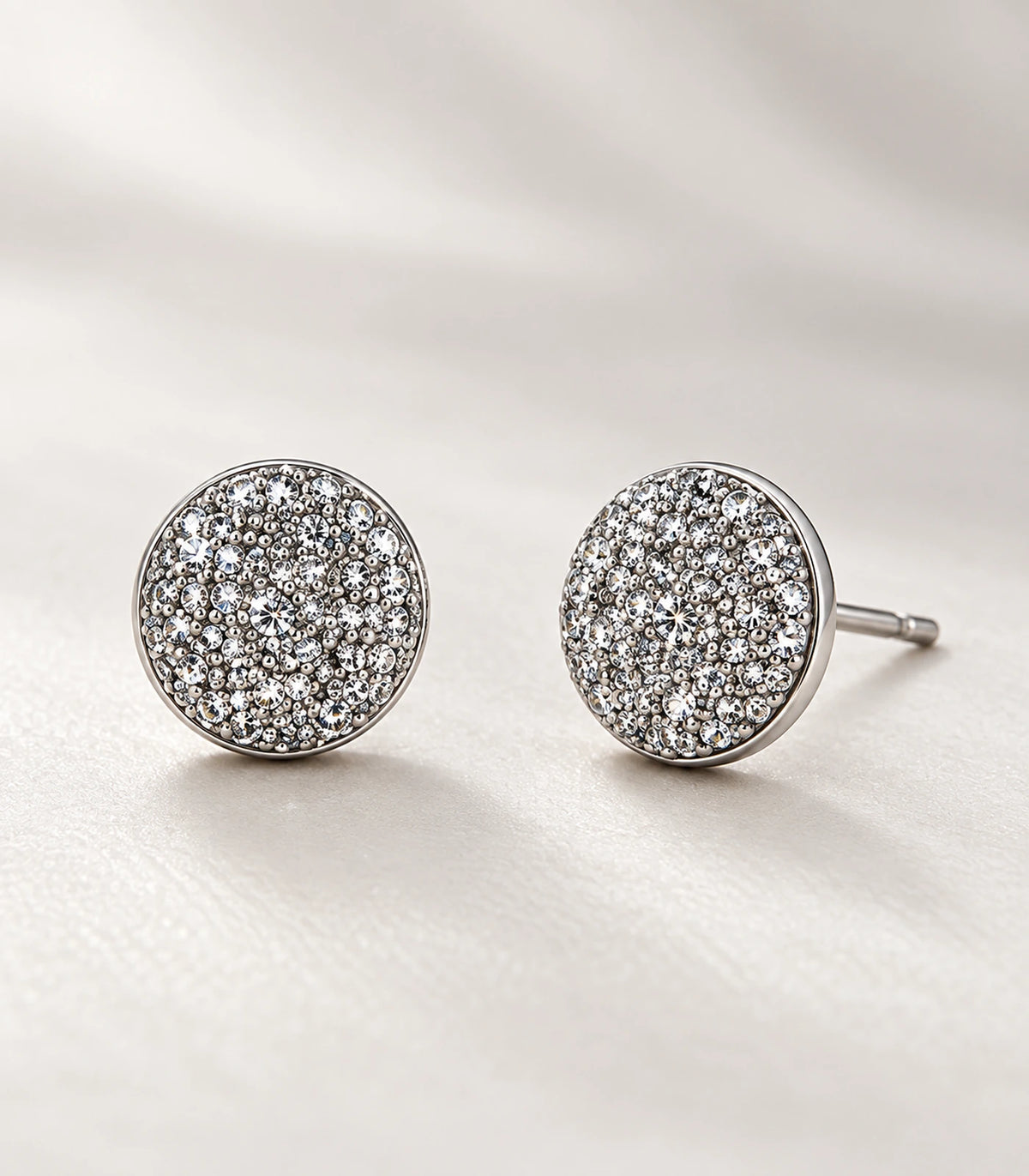 Close view of the matching silver-tone pavé round disc stud earrings