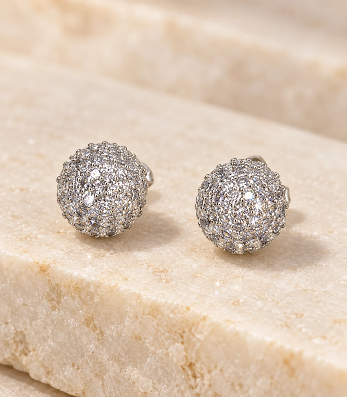 Close view of the pavé detail on a pair of silver-tone sphere studs