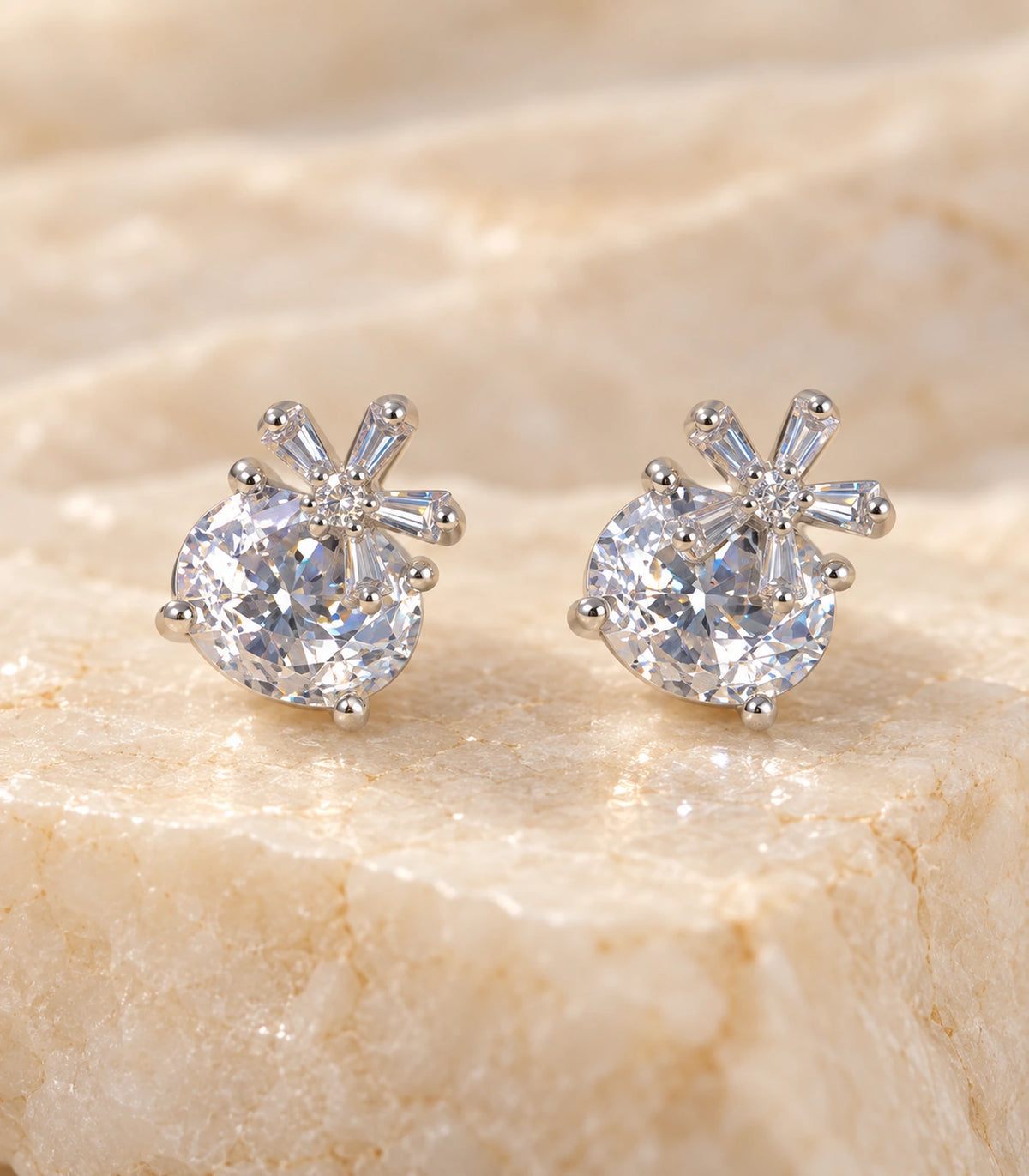 Close view of the pair of silver-tone round crystal-style and baguette burst stud earrings