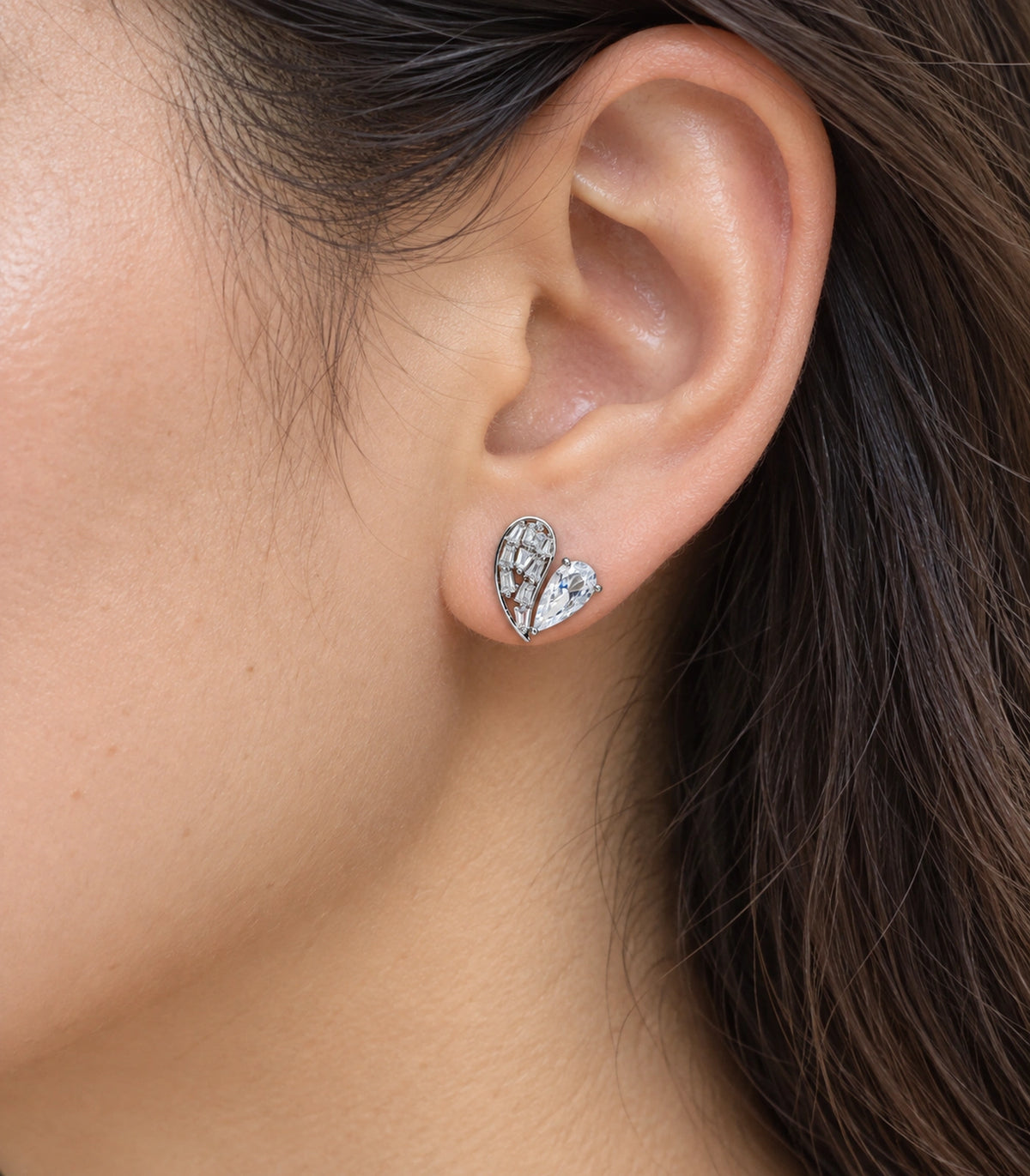 JIMIKI Asymmetric Crystal Heart Stud Earring Pair in Silver Tone, close-up detail #color_silver tone