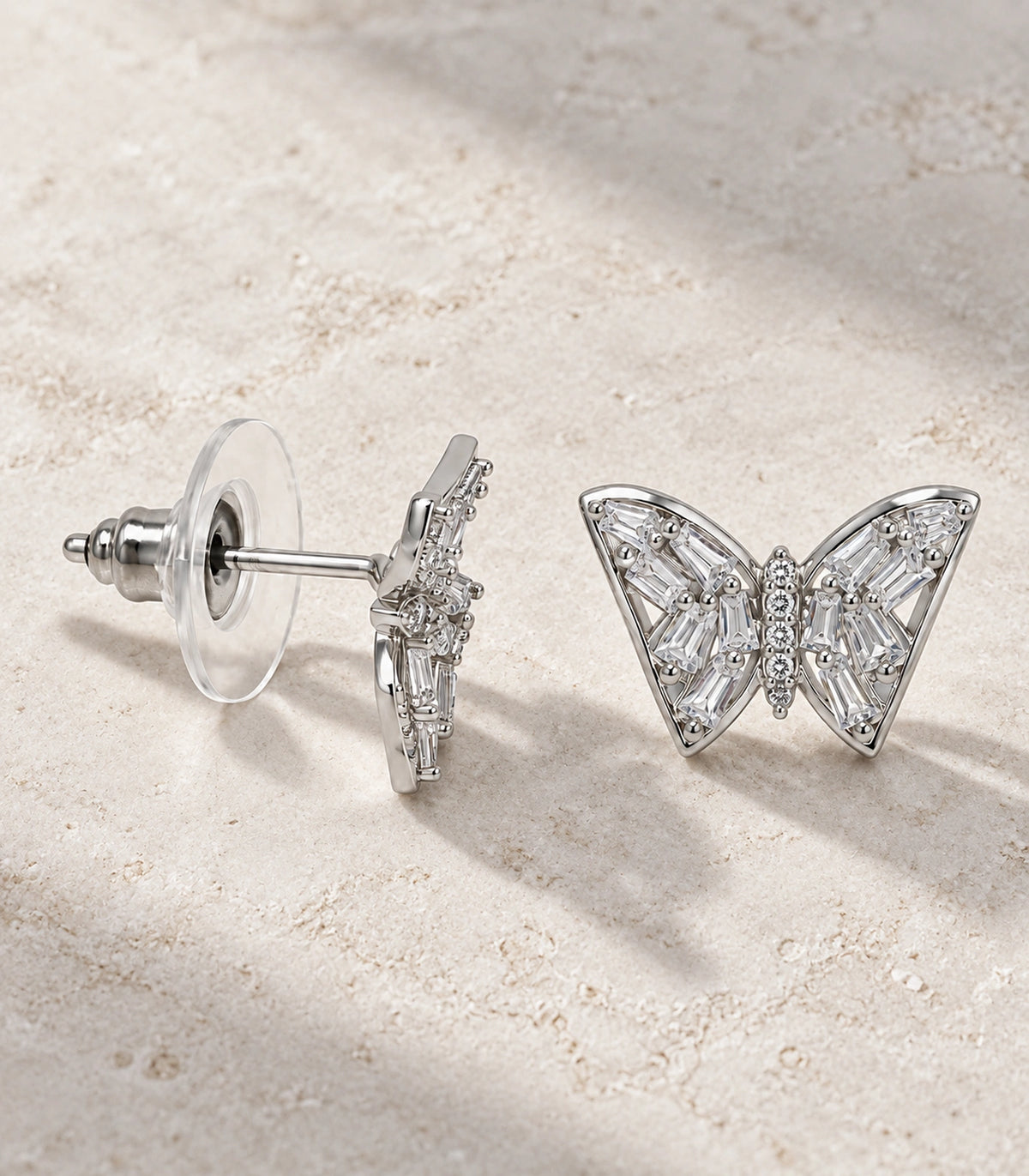 JIMIKI Silver-Tone Baguette Wing Butterfly Stud Earrings in Silver-tone, editorial flat lay