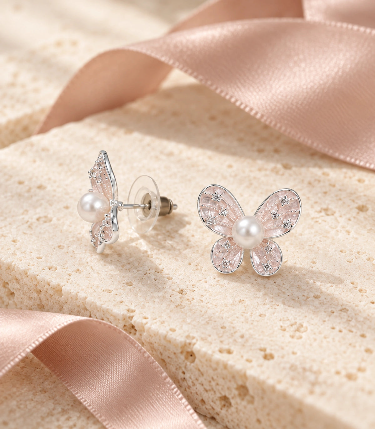 JIMIKI Silver Tone Blush Pink Pearl Butterfly Stud Earring Pair in Blush pink, editorial flat lay